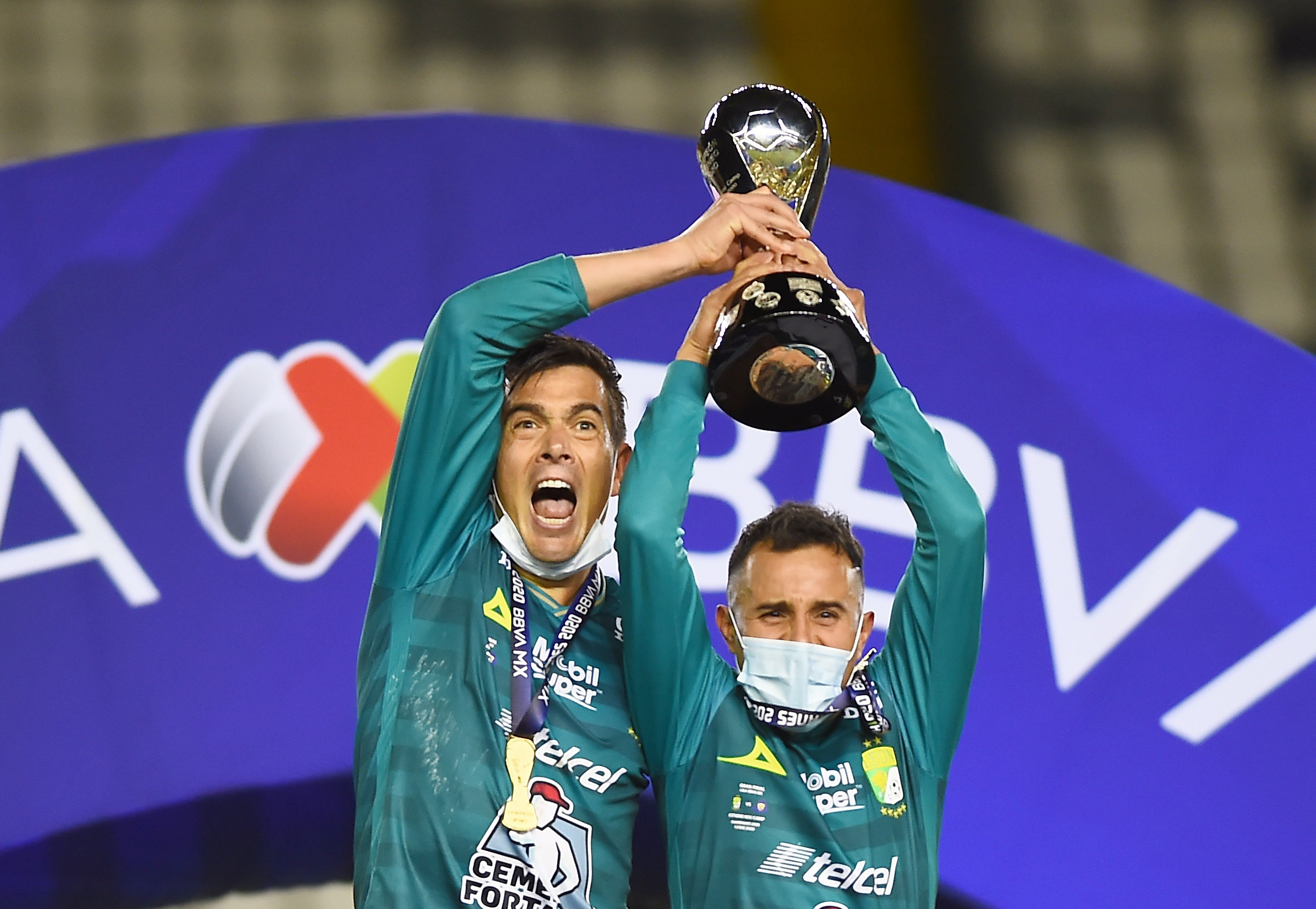 Juan Gonzalez y Luis Montes celebran con el trofeo de la Liga MX.