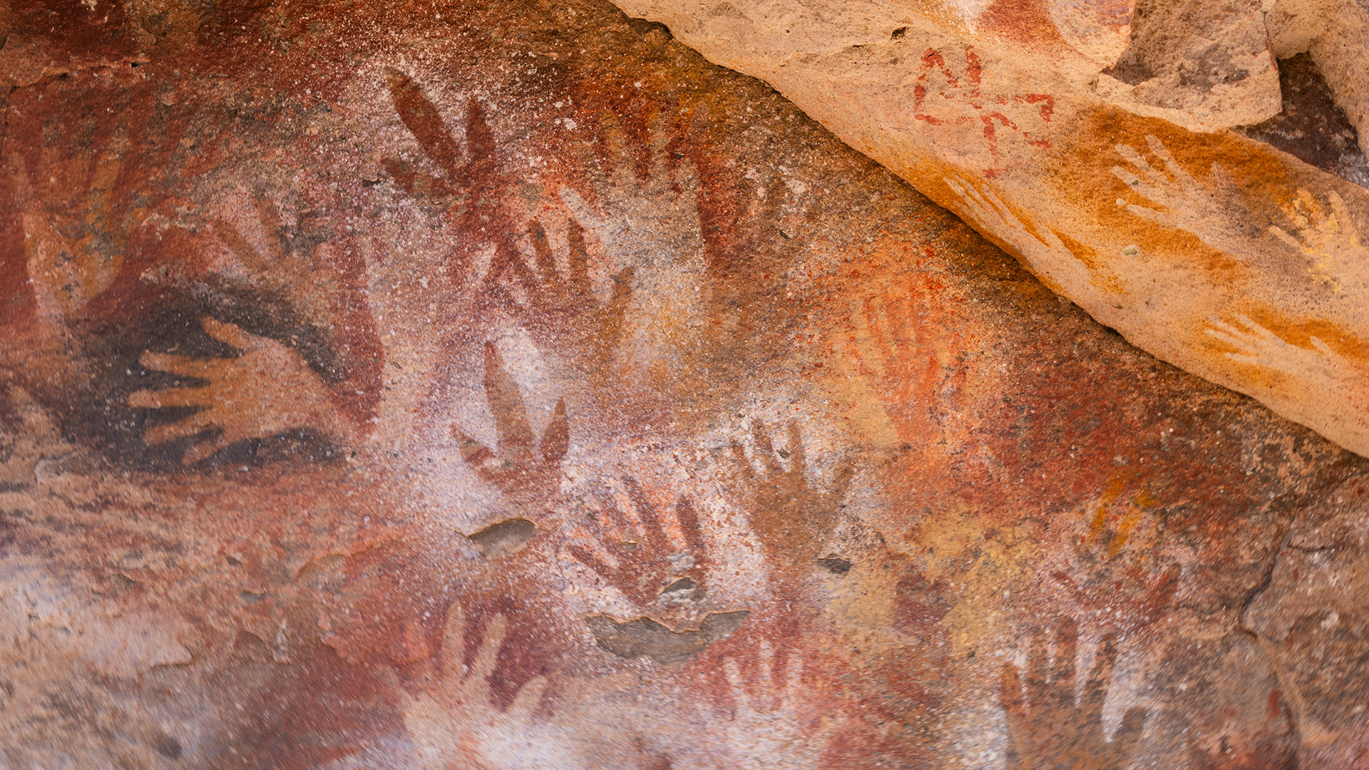 Paredes cubiertas de manos, huellas de animales y s&iacute;mbolos que a&uacute;n intrigan: Infobae entre pinturas rupestres milenarias