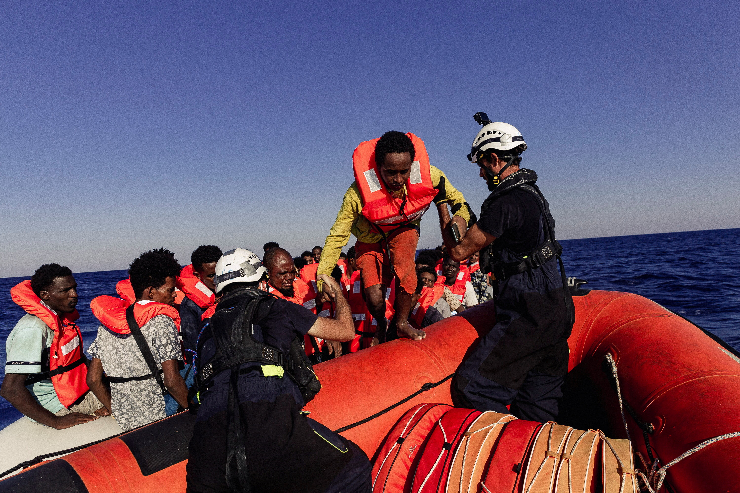 Un miembro de la tripulación de Sea-Watch ayuda a un migrante a embarcar en una lancha neumática en el mar Mediterráneo, 23 de julio de 2022. Nora Bording/Sea-Watch/Handout via REUTERS/Archivo