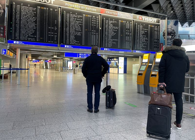 FOTO DE ARCHIVO: Pasajeros frente a un horario que muestra muchos vuelos cancelados en el aeropuerto de Fráncfort durante una huelga del personal de seguridad en varios aeropuertos alemanes para presionar a la dirección en las negociaciones salariales en Fráncfort, Alemania, 15 de marzo de 2022. REUTERS/Timm Reichert