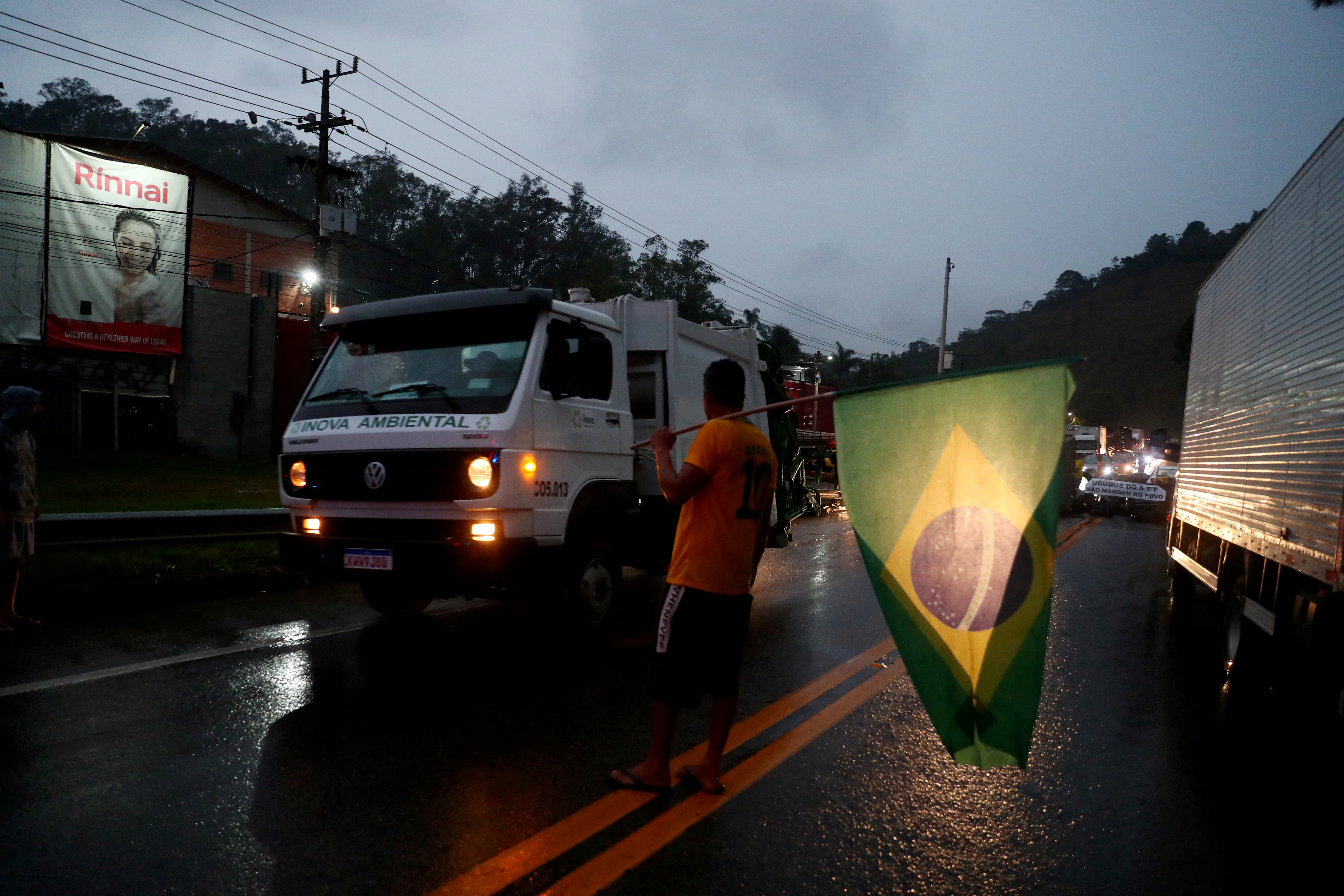 Un simpatizante de Bolsonaro con una bandera de Brasil en medio de un bloqueo de camioneros (REUTERS/Pilar Olivares)