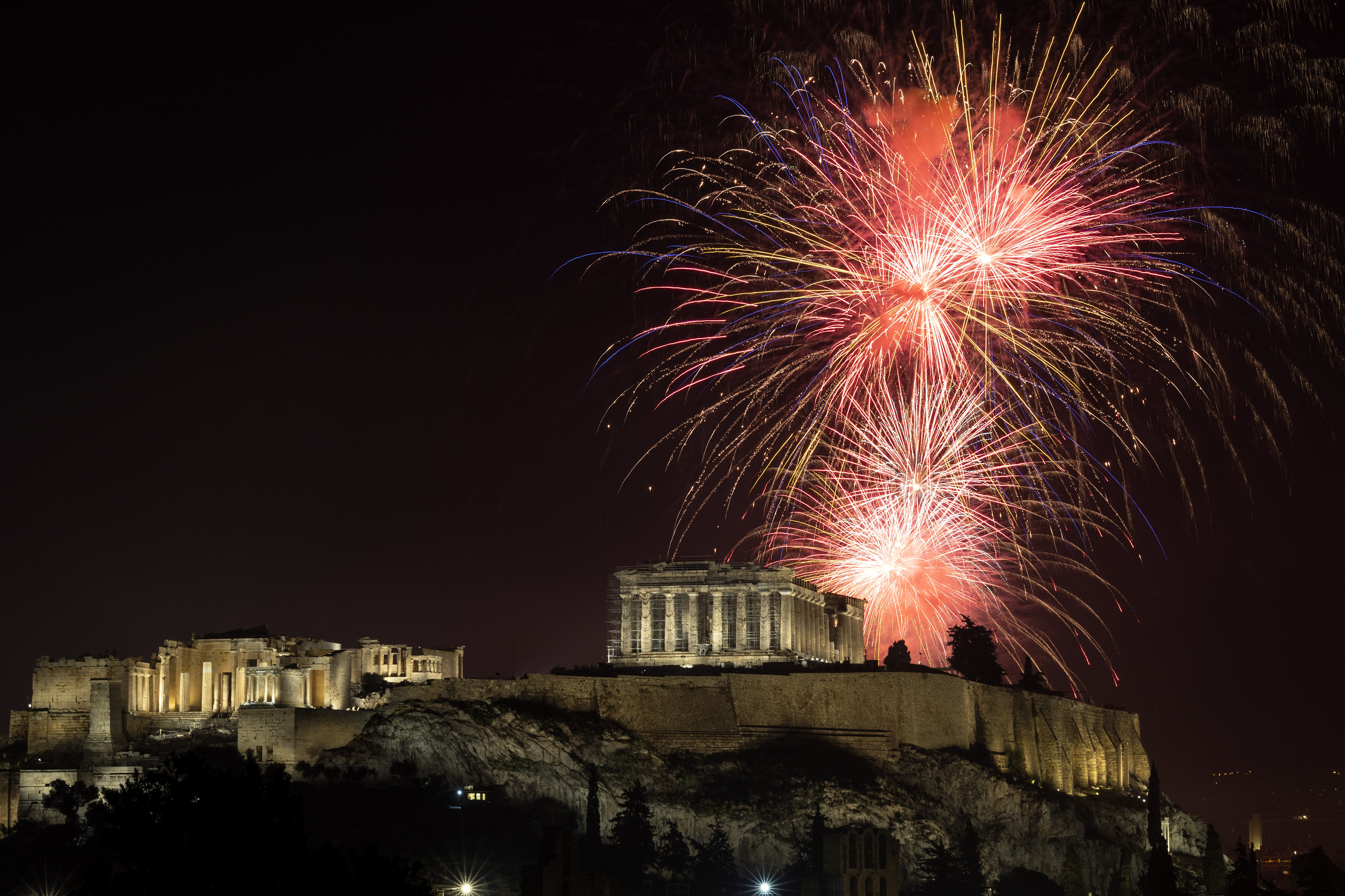 Fuegos artificiales explotan sobre el Partenón, en la Acrópolis, durante la celebración del año nuevo, en Atenas, Grecia, el 1 de enero de 2023. (AP Foto/Yorgos Karahalis)