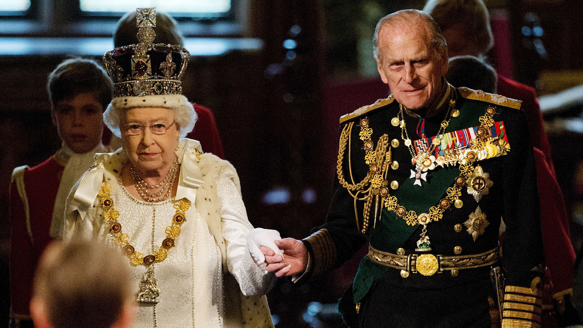 En esta foto de archivo tomada el 9 de mayo de 2012, la reina Isabel II y el príncipe Felipe, duque de Edimburgo, atraviesan la Galería Real en el Palacio de Westminster