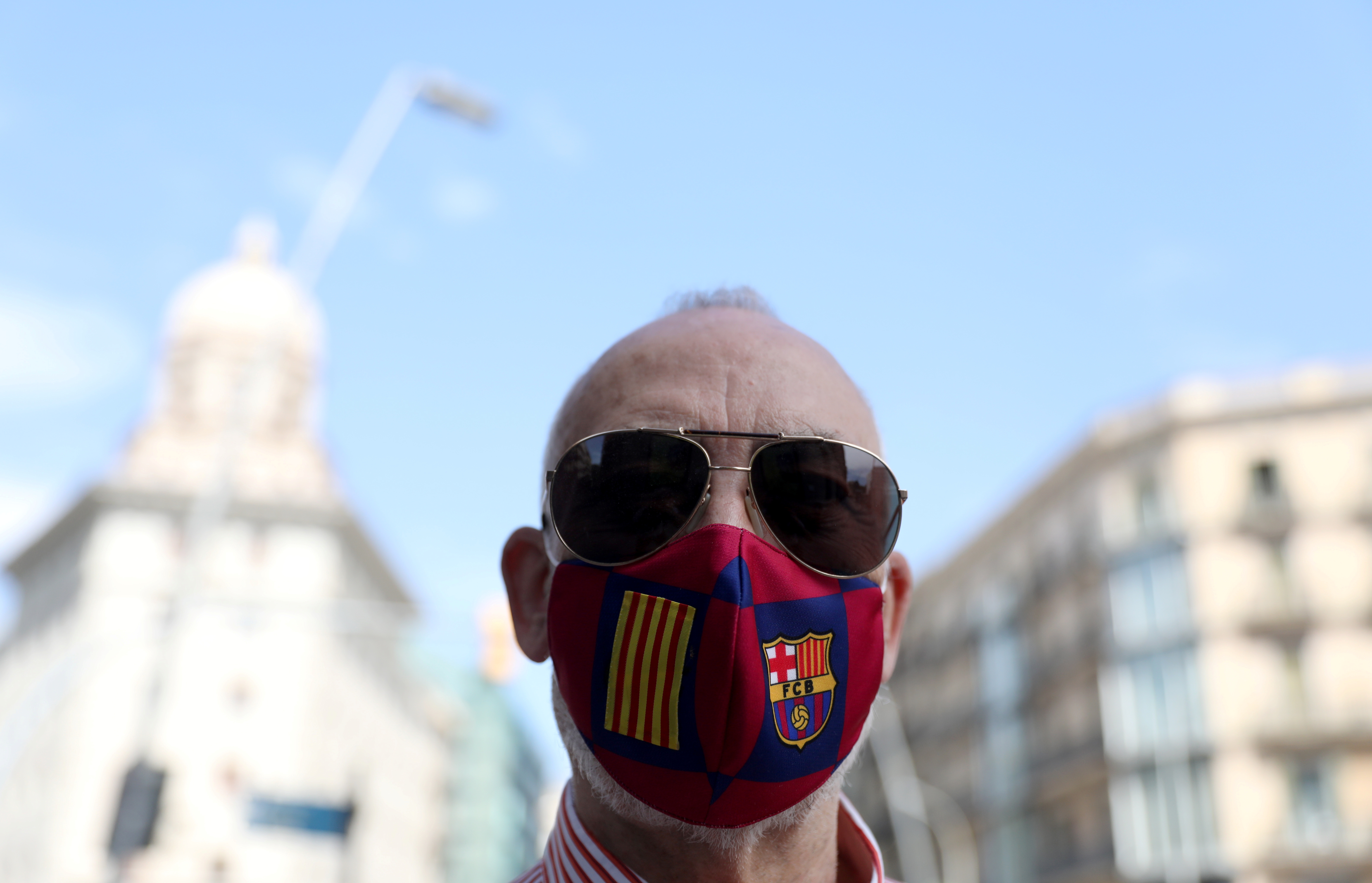 Un hombre con un barbijo del club de fútbol de Barcelona en Plaza Catalunya (REUTERS/Nacho Doce)