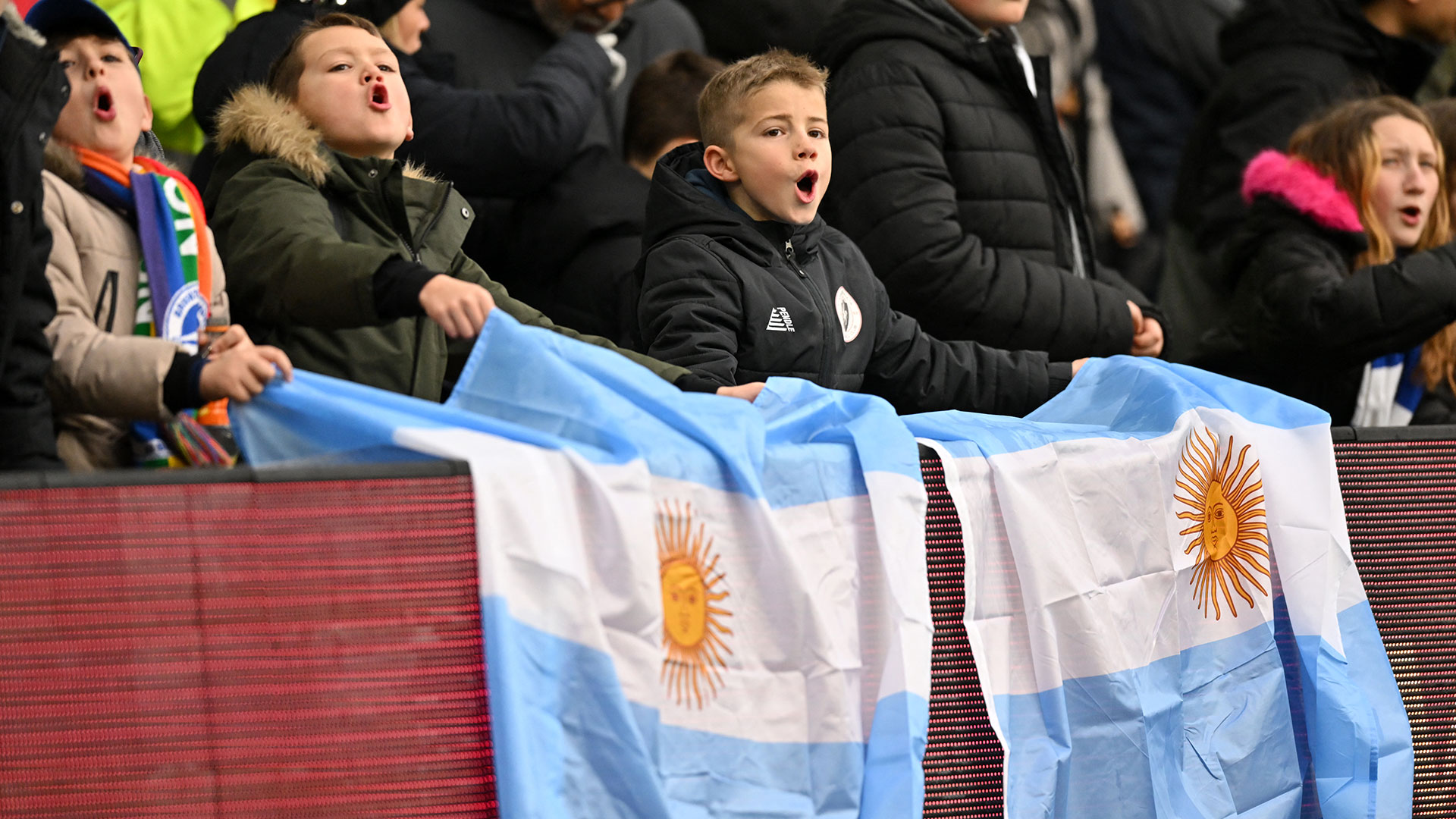 Los jóvenes fanáticos del Brighton con banderas de Argentina en honor a Alexis Mac Allister (Photo by Glyn KIRK / AFP)
