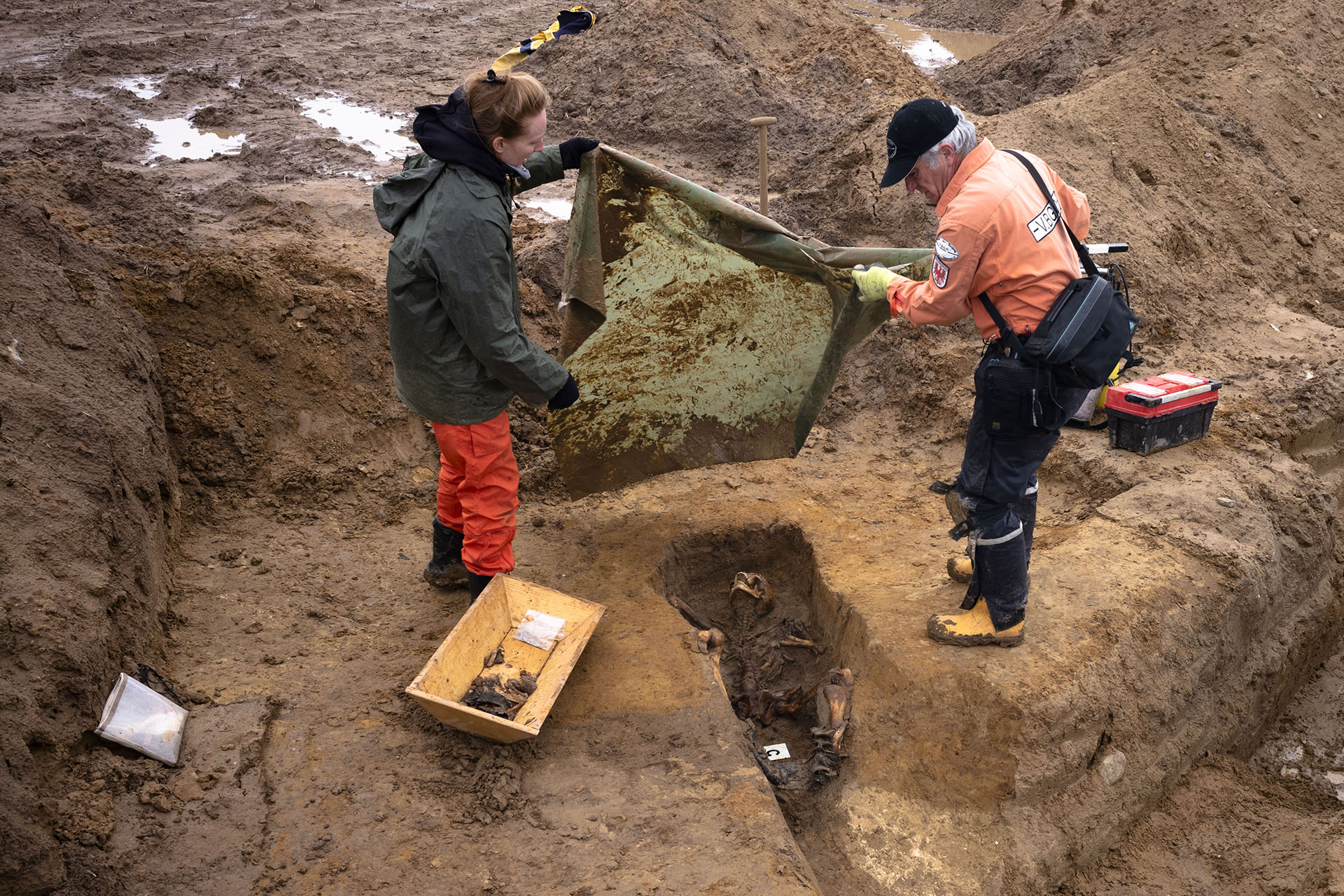 Laura Tradii, izquierda, antropóloga social de la Universidad de Cambridge y Werner Schulz, derecha, un técnico de excavación, cubren los restos de un soldado soviético (Foto AP / Markus Schreiber)