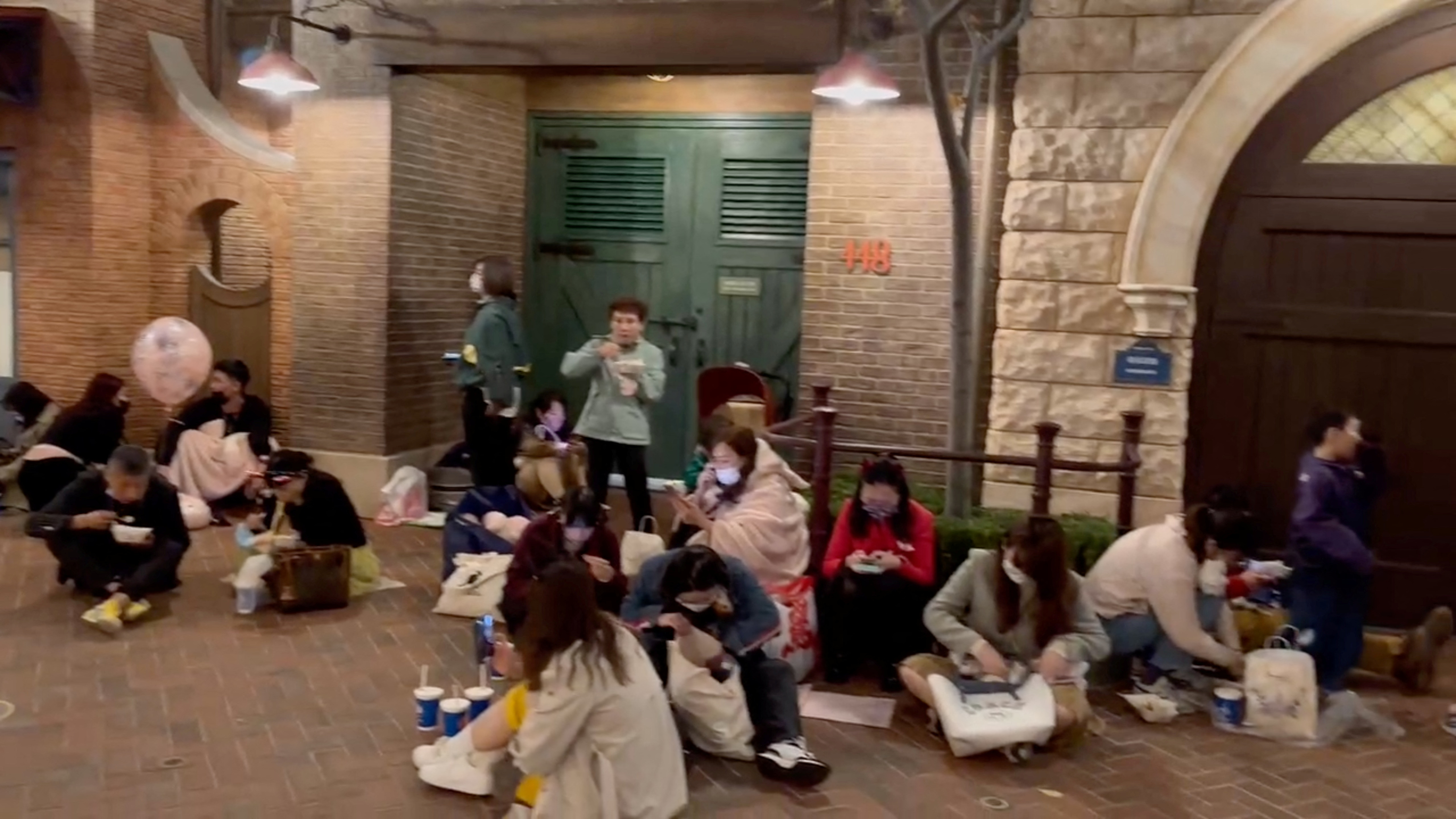 Personas sentadas en el piso tras ser encerradas en el parque Disney Resort (Reuters)