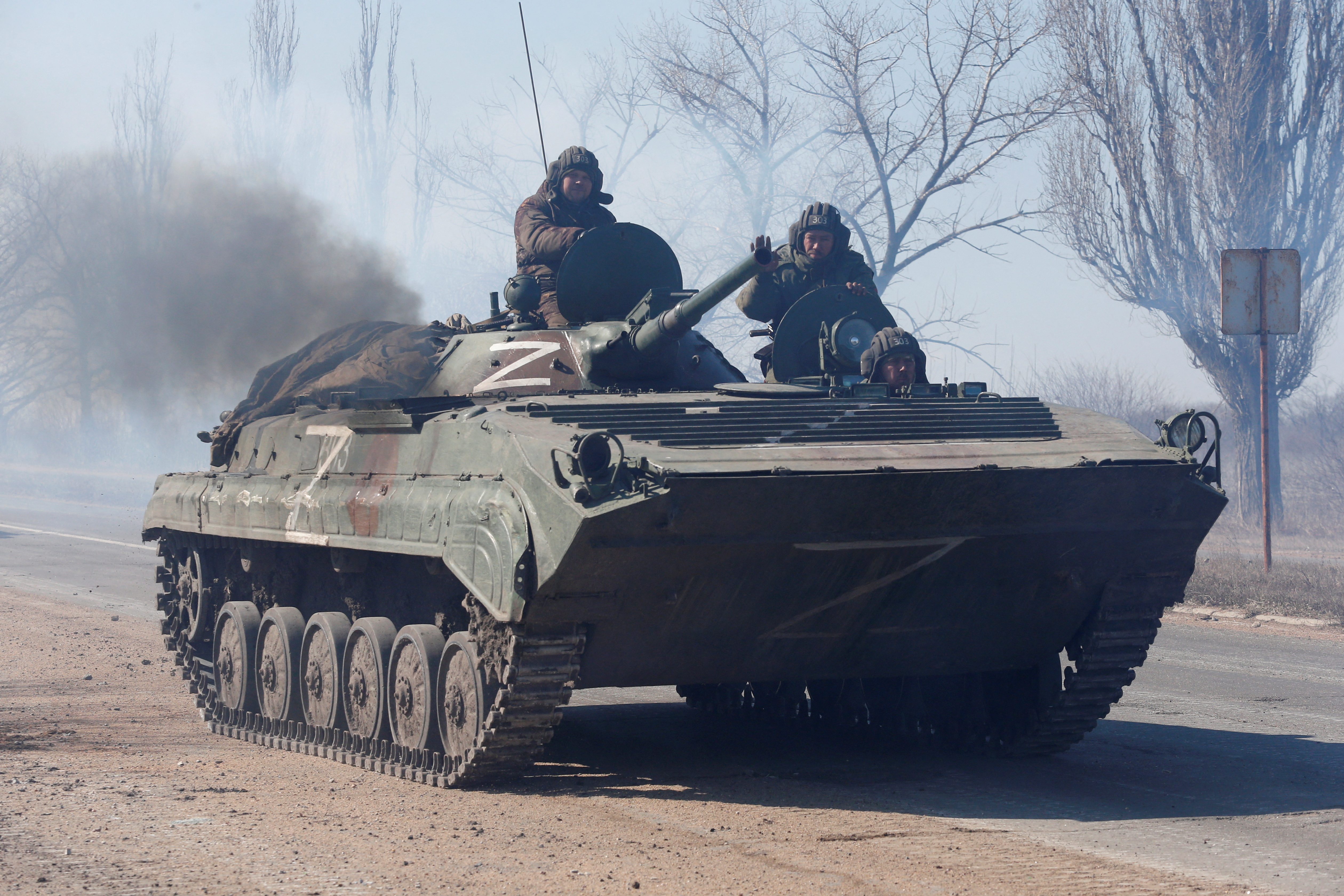 Miembros del servicio de las tropas prorrusas con uniformes sin insignias se ven encima de un vehículo blindado (Reuters)