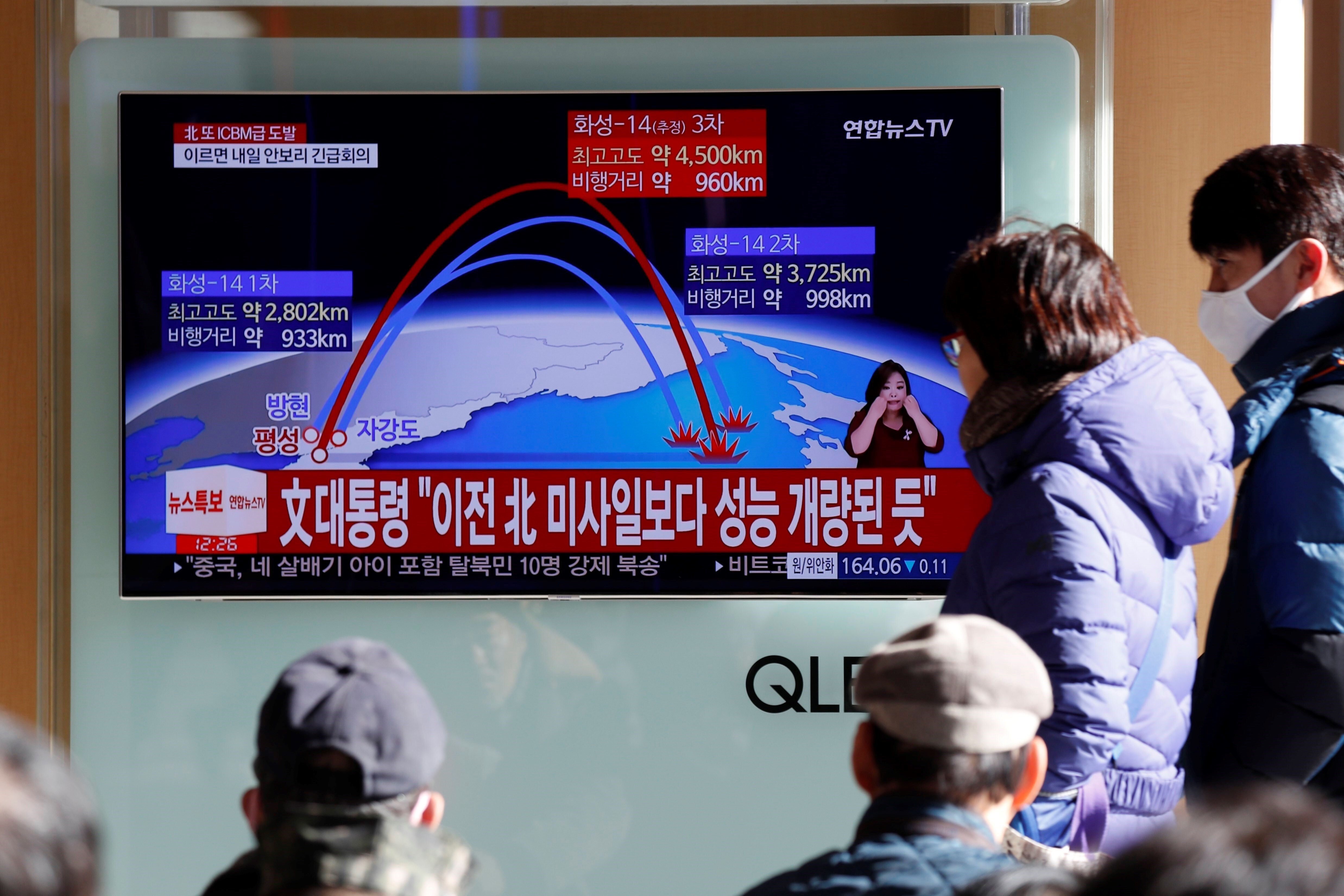 Surcoreanos ven un reportaje televisivo que muestra el anuncio especial de Corea del Norte de que ha probado con éxito un misil balístico intercontinental (ICBM)
