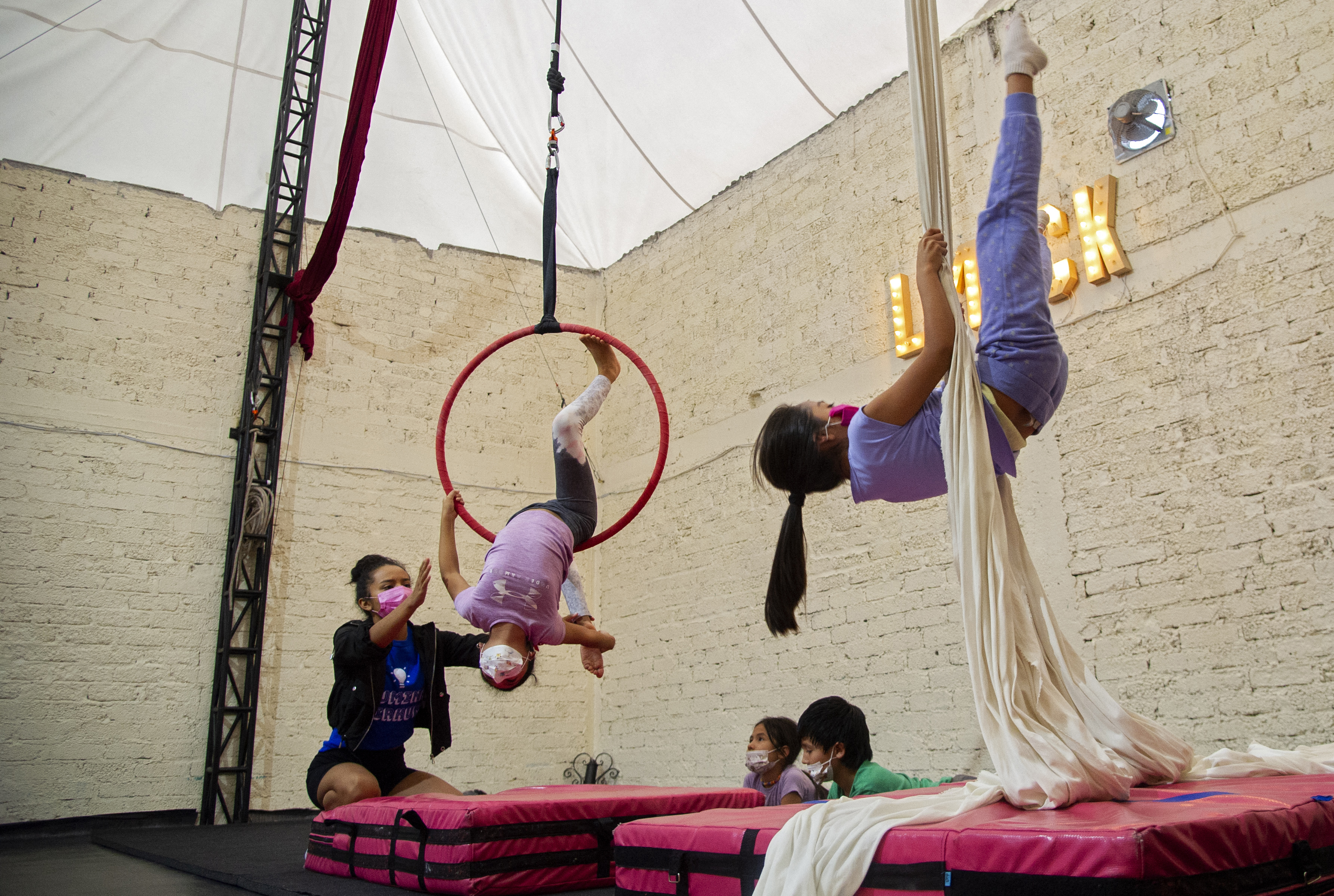 Niños colgados de aros mientras los aspirantes a acróbatas se balancean en la cuerda floja o giran en el aire en una escuela de circo familiar en México, decididos a mantener vivos sus sueños a pesar de la pandemia
FOTO: CLAUDIO CRUZ / AFP