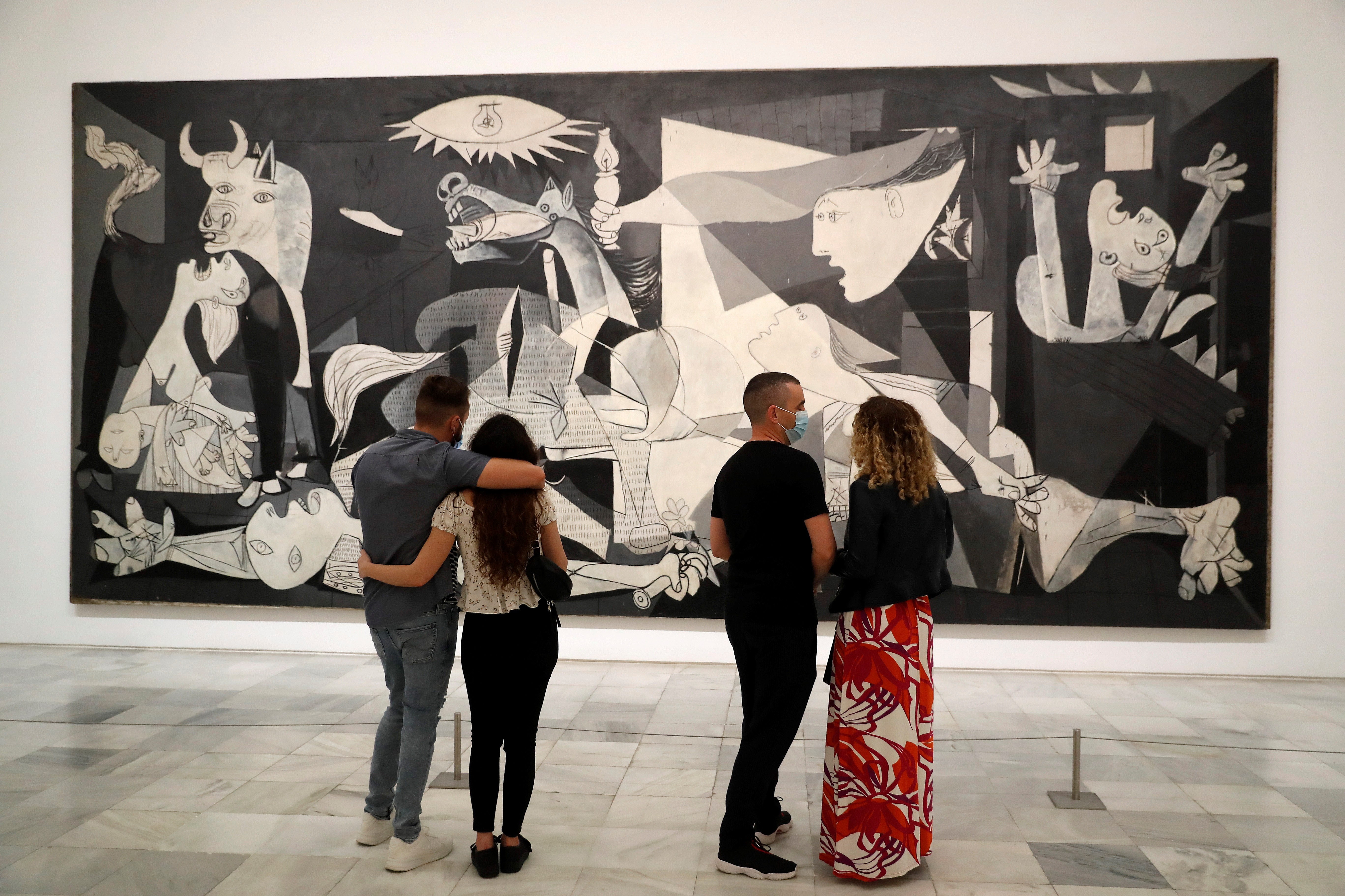 Varias personas observan "El Guernica" de Pablo Picasso en el museo Reina Sofía, tras su reapertura (EFE/ Chema Moya)
