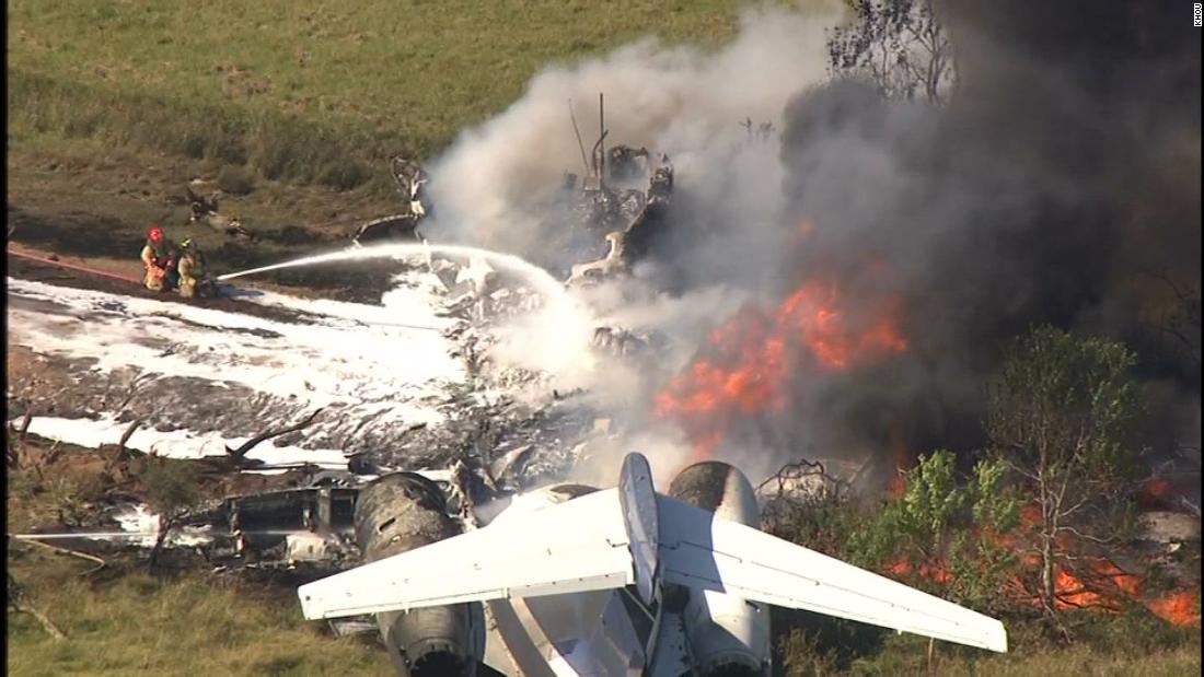 Un grupo de bomberos intenta sofocar las llamas de un avión siniestrado 