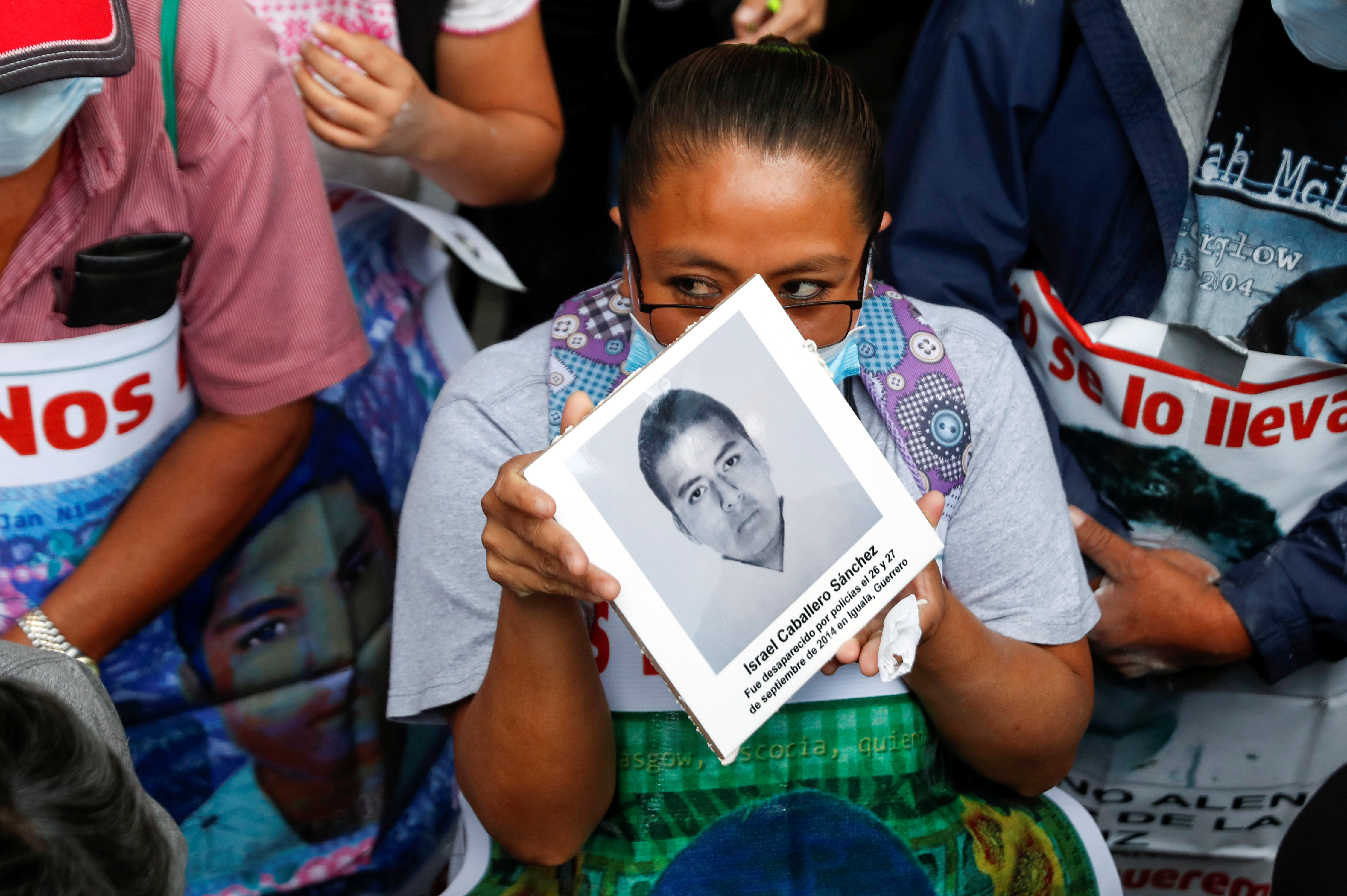 Familiares de estudiantes desaparecidos sostienen carteles con sus imágenes mientras participan en una protesta frente a la Fiscalía General de la República, antes del sexto aniversario de la desaparición de 43 estudiantes de la Escuela Normal Rural de Ayotzinapa, en la Ciudad de México, México 25 de septiembre de 2020.