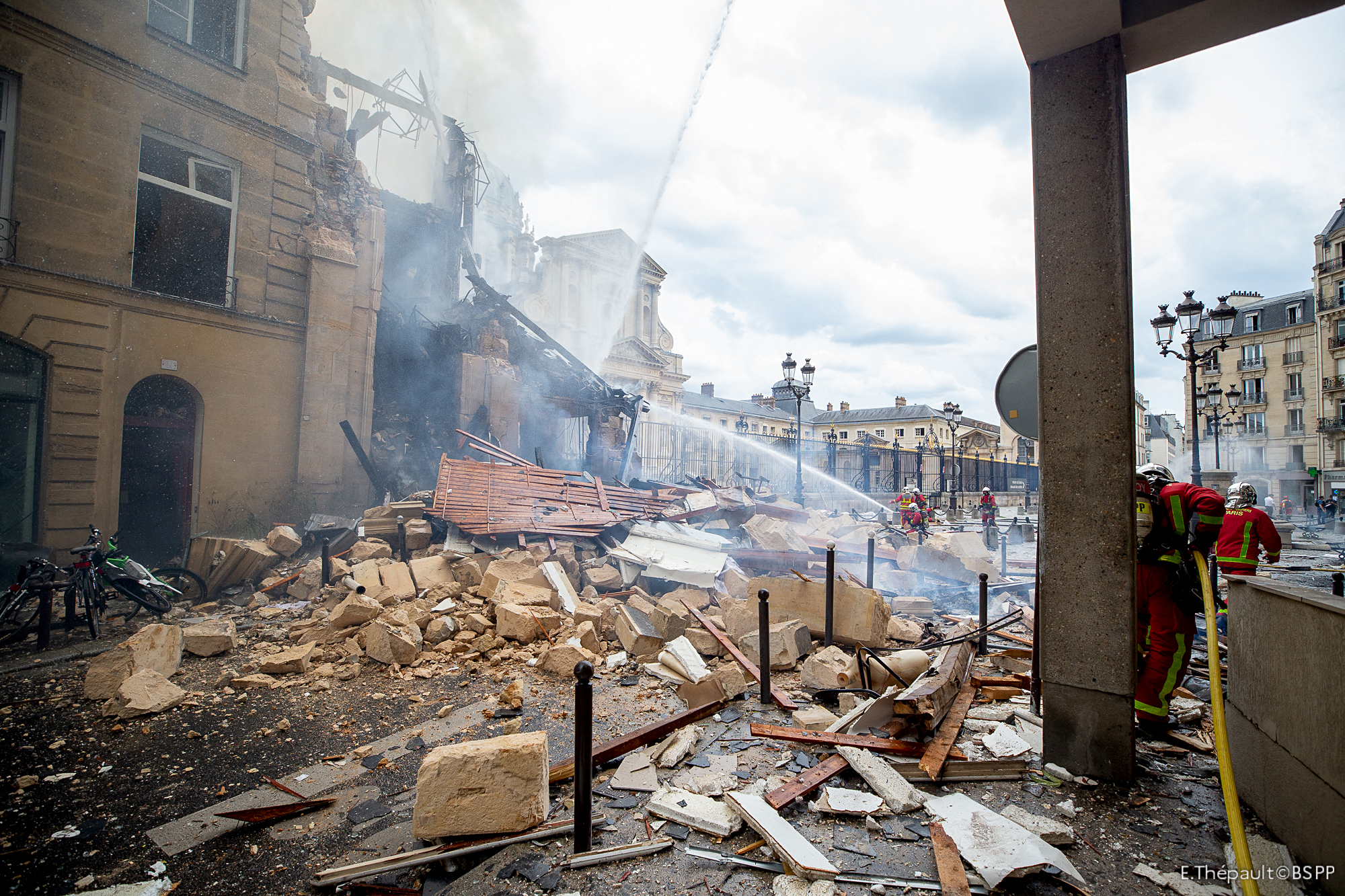 Bomberos mientras intentan extinguir un incendio en París el 21 de junio de 2023, después de que una explosión arrasara un edificio en el centro de la capital francesa, cerca del antiguo hospital militar Val-de-Grace (AFP)
