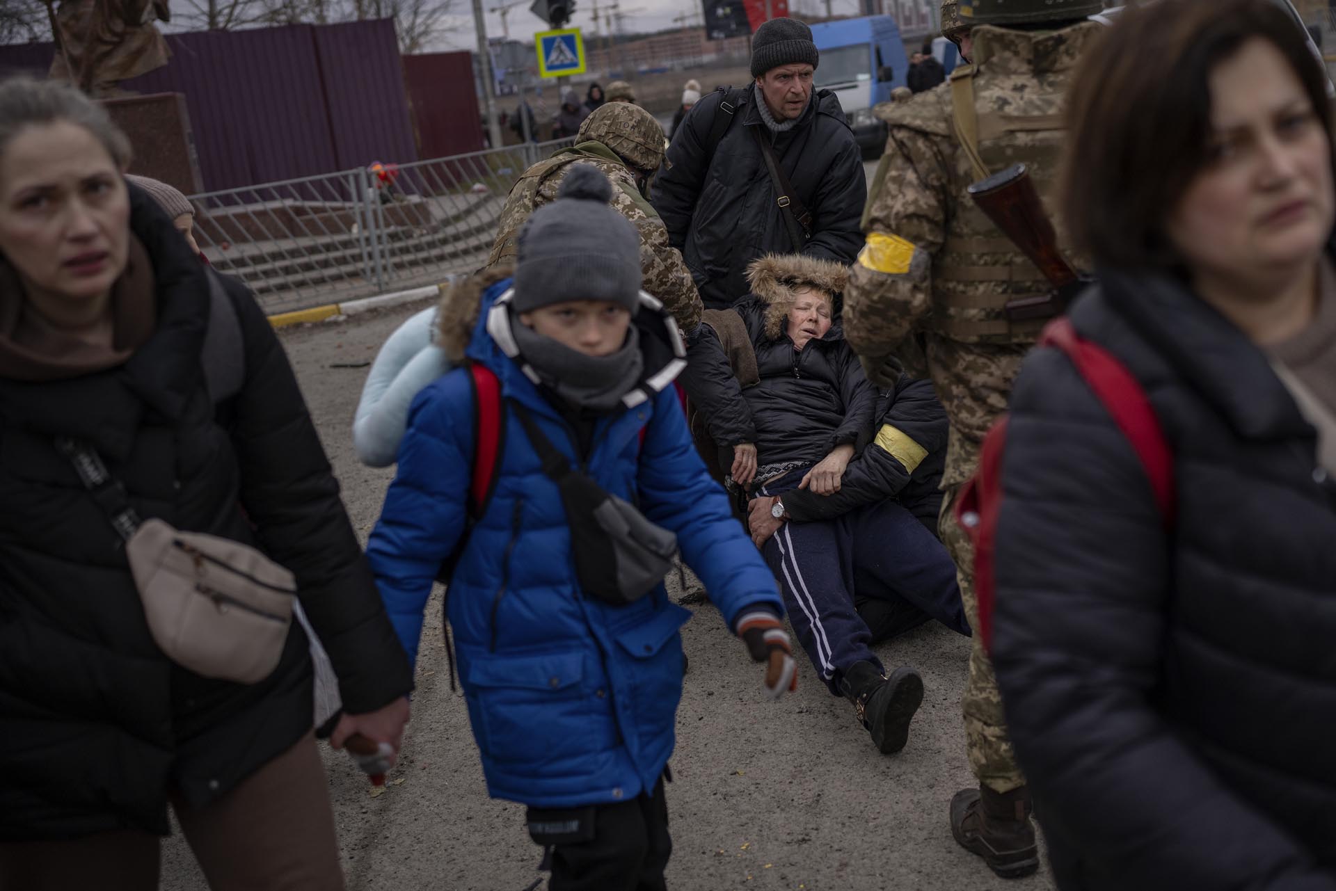 Mientras se oye el ruido cercano de artillería, varias personas huyen de Irpin, a las afueras de Kiev, Ucrania, el lunes 7 de marzo de 2022. 