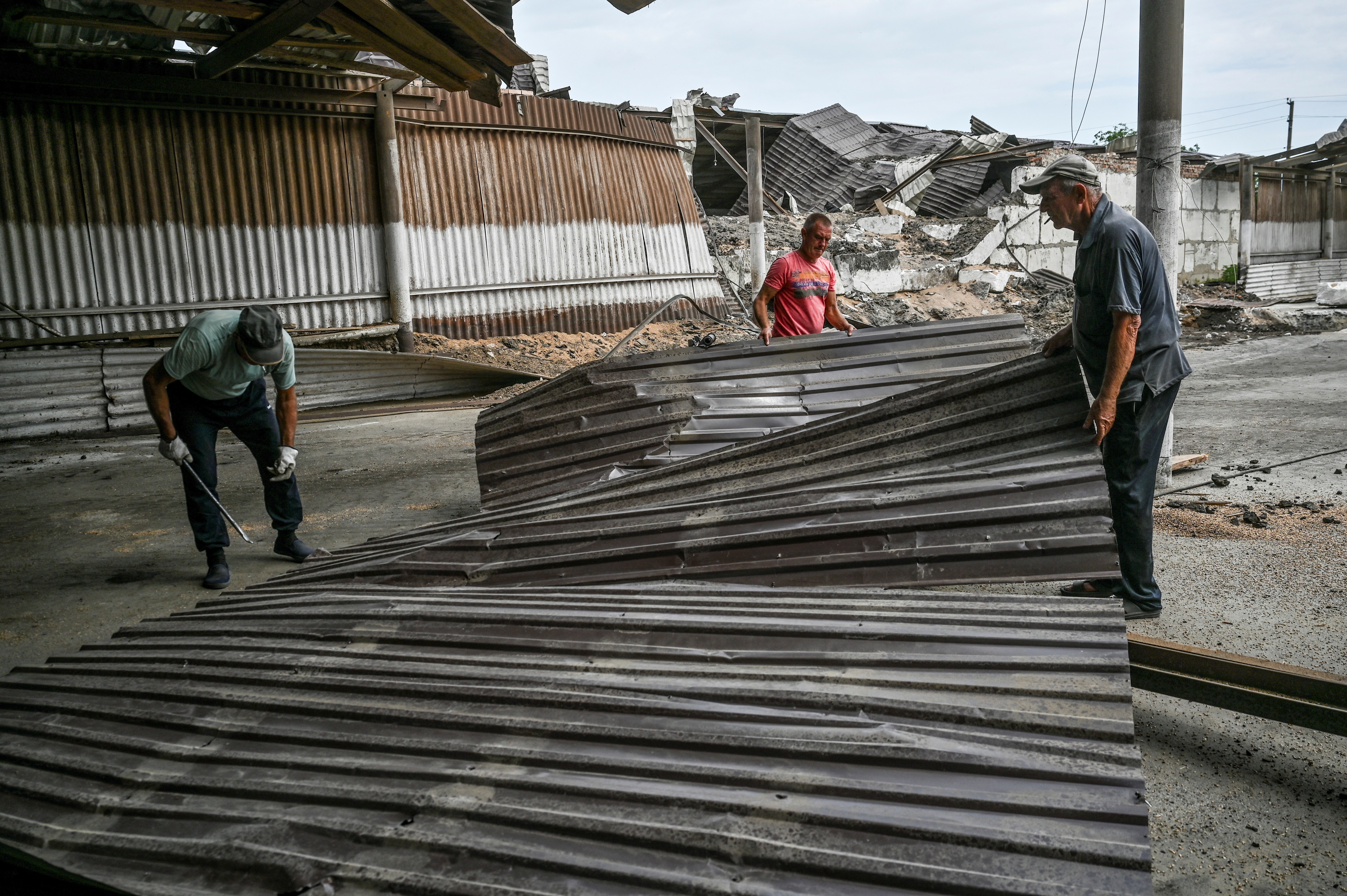 Empleados retiran los restos de un almacén de trigo dañado por un ataque de misiles rusos, mientras continúa el ataque de Rusia a Ucrania, en la región de Zaporizhzhia, Ucrania, el 5 de agosto de 2022.  REUTERS/Dmytro Smolienko