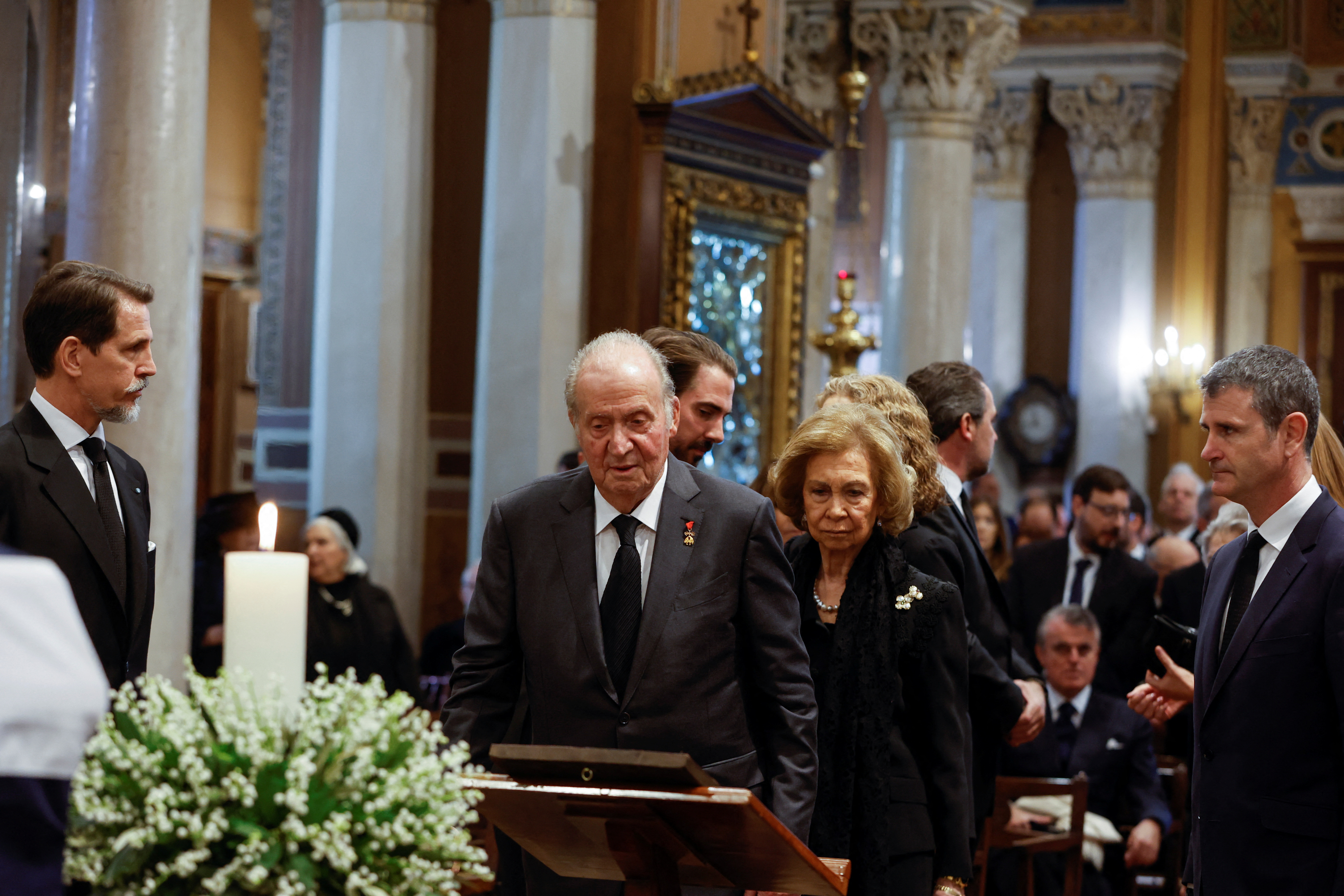Juan Carlos I con la reina Sofía en el funeral del hermano de esta, Constantino de Grecia. 