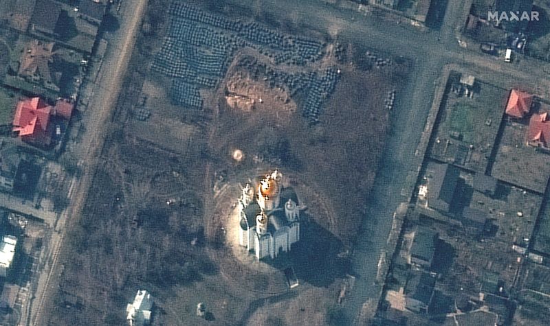 Una imagen de satélite muestra una fosa común junto a una iglesia en BUcha (Maxar/Reuters)