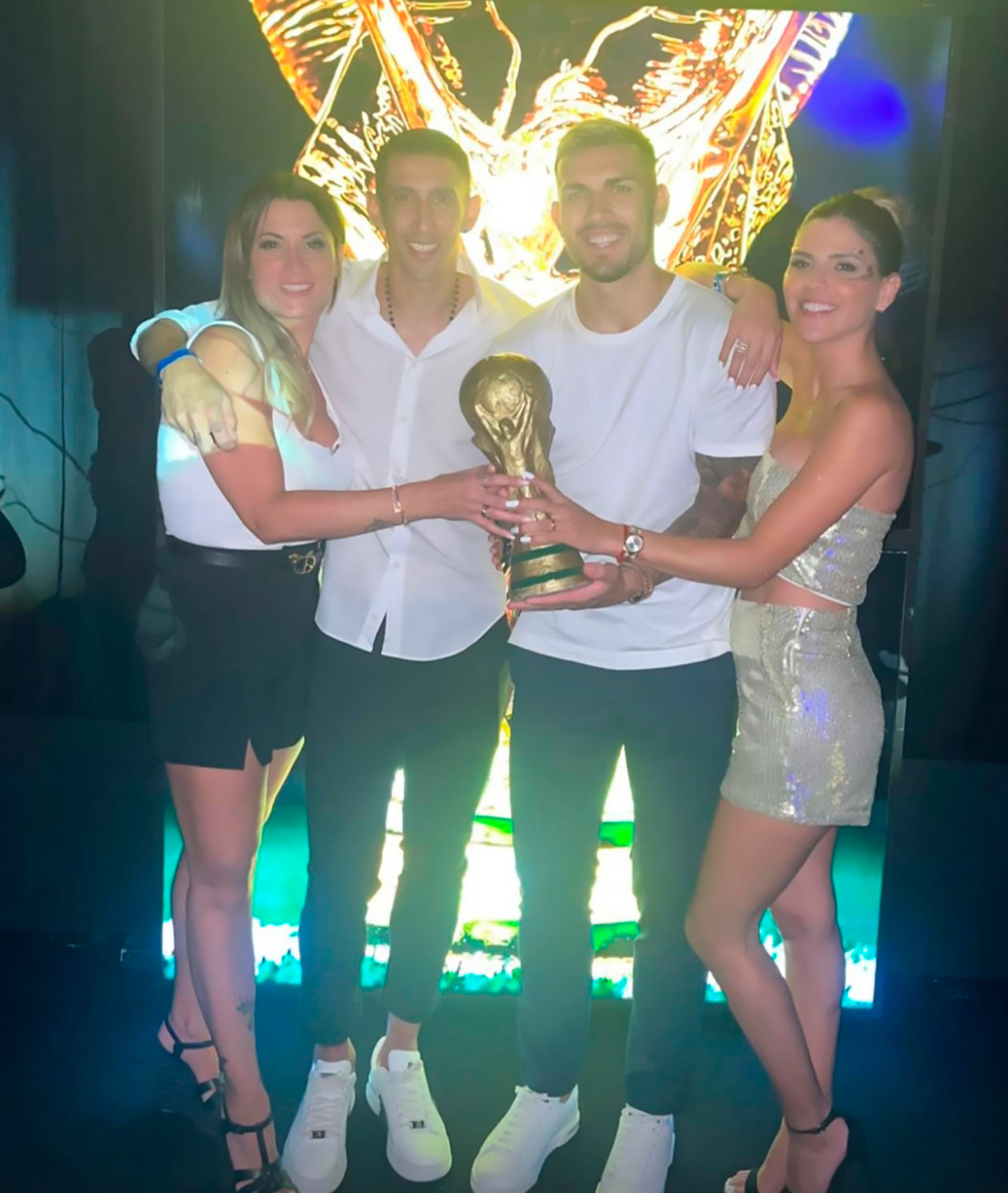Ángel Di María y Leandro Paredes, junto a sus parejas, con la Copa del Mundo