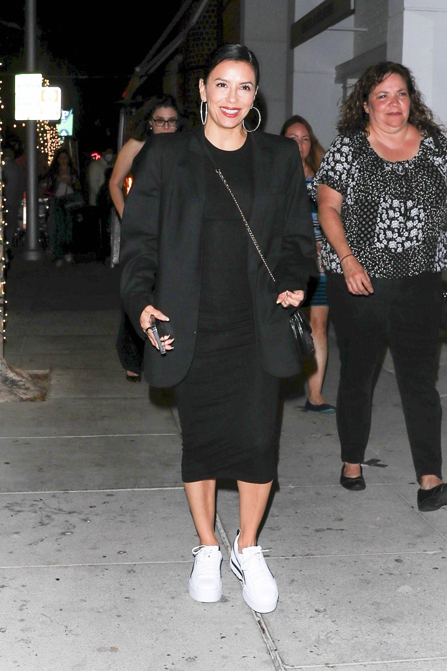 Eva Longoria muy sonriente, con un vestido negro y zapatillas blancas, fue a cenar con su familia en Mr Chow en Beverly Hills