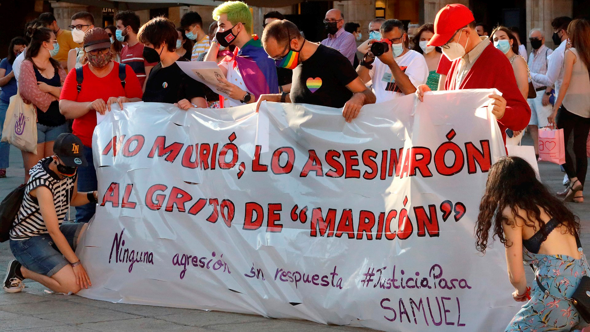Manifestantes sostienen una bandera con la leyenda "No murió, lo mataron al grito de 'maricón'" (Foto: EFE)
