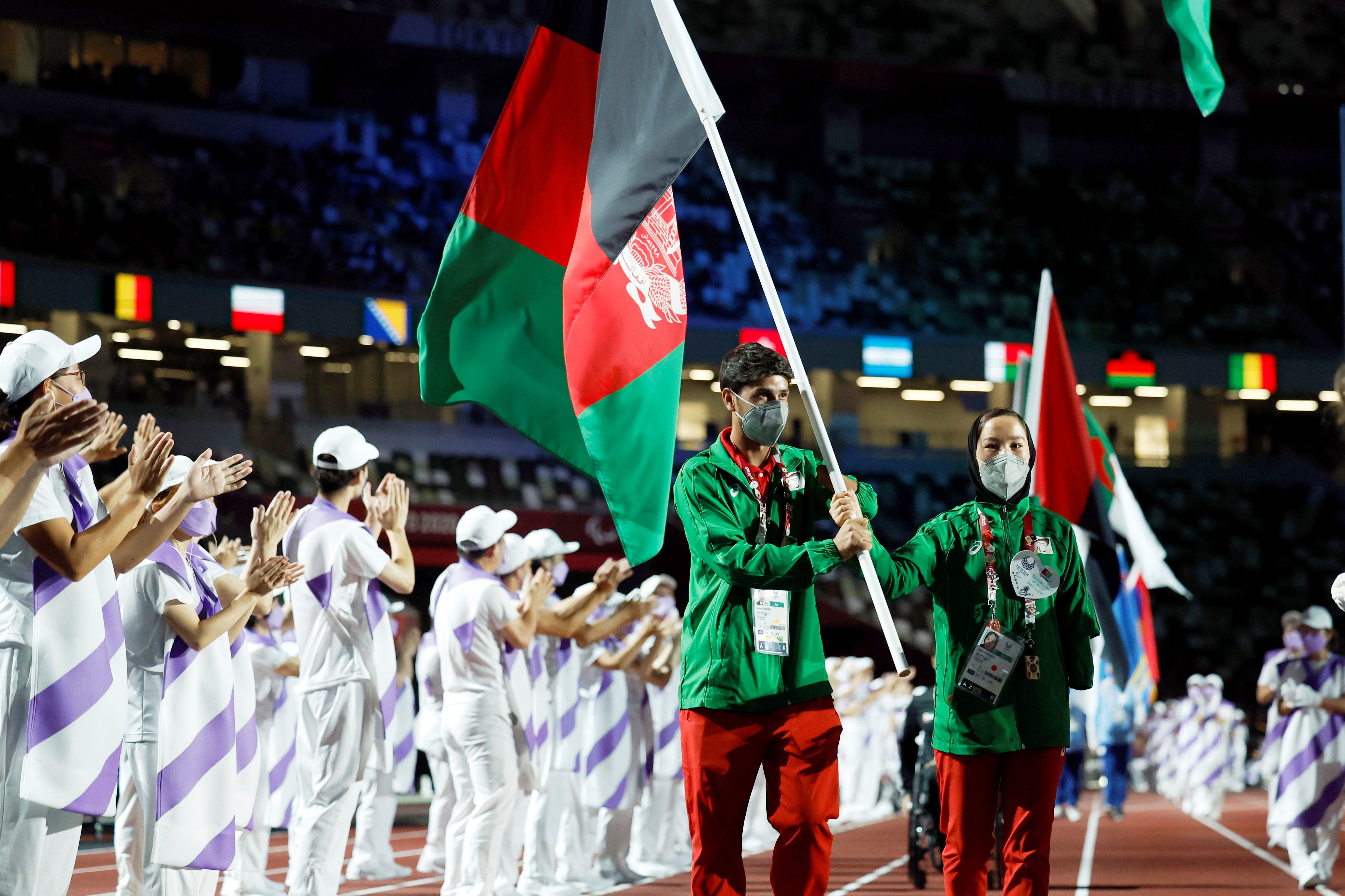 Tokyo 2020 Paralympic Games - The Tokyo 2020 Paralympic Games Closing Ceremony - Olympic Stadium, Tokyo, Japan - September 5, 2021. Hossain Rasouli of Afghanistan and Zakia Khudadadi of Afghanistan carry the flag of Afghanistan during the closing ceremony  REUTERS/Issei Kato     TPX IMAGES OF THE DAY