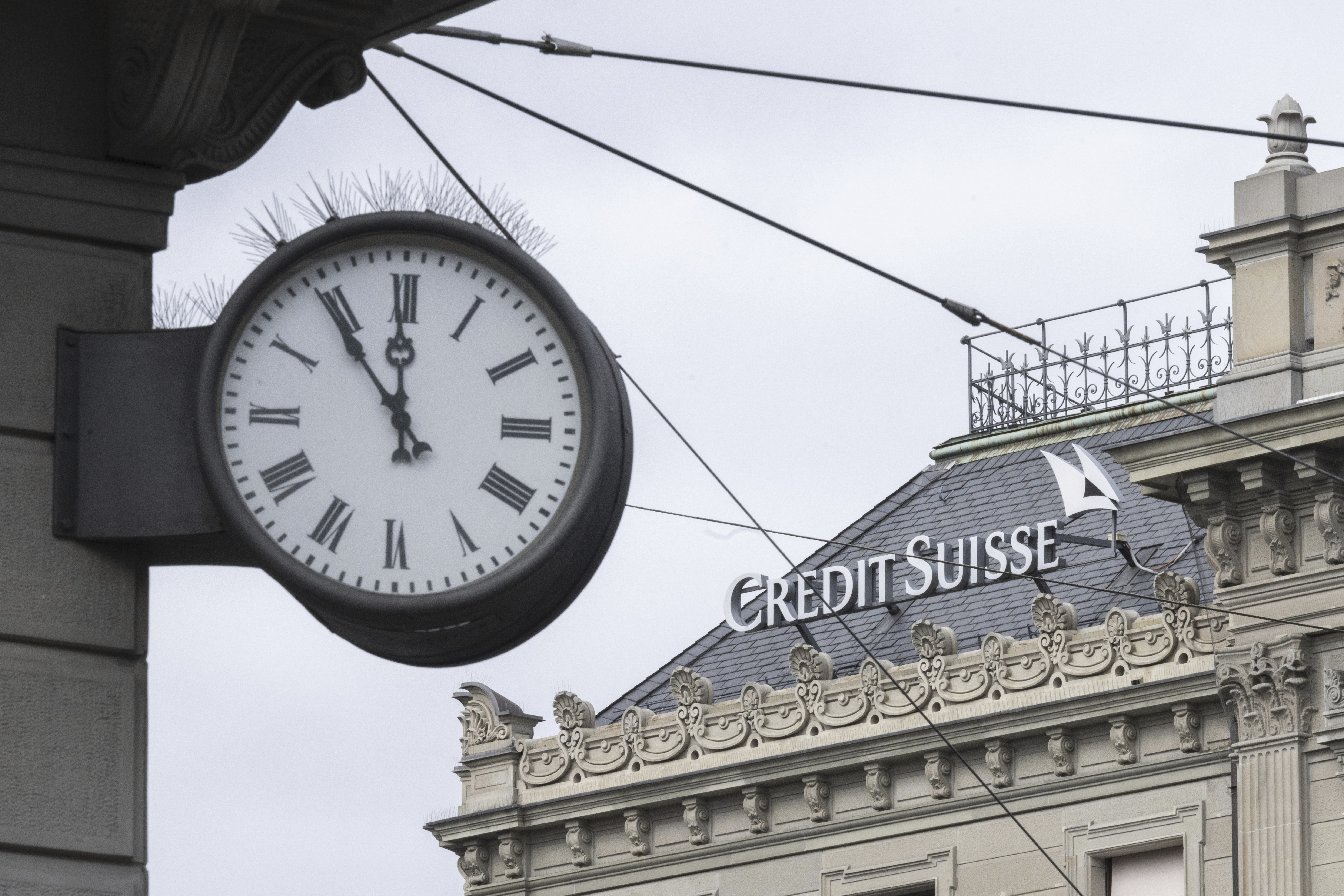 Un reloj al lado del logo del banco Credit Suisse, en Zúrich (Ennio Leanza/Keystone via AP)