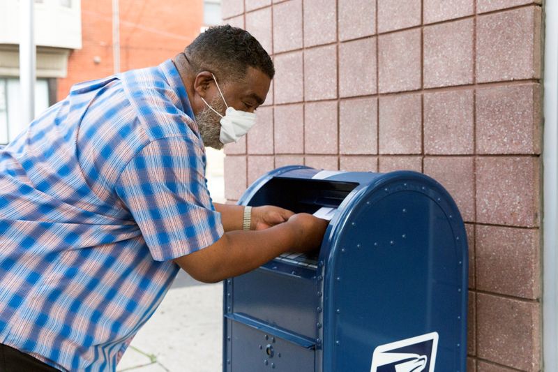 Una persona deposita cartas en un buzón de cobranza del Servicio Postal de EEUU en Filadelfia, Pensilvania. 14 de agosto de 2020.  REUTERS/Rachel Wisniewski