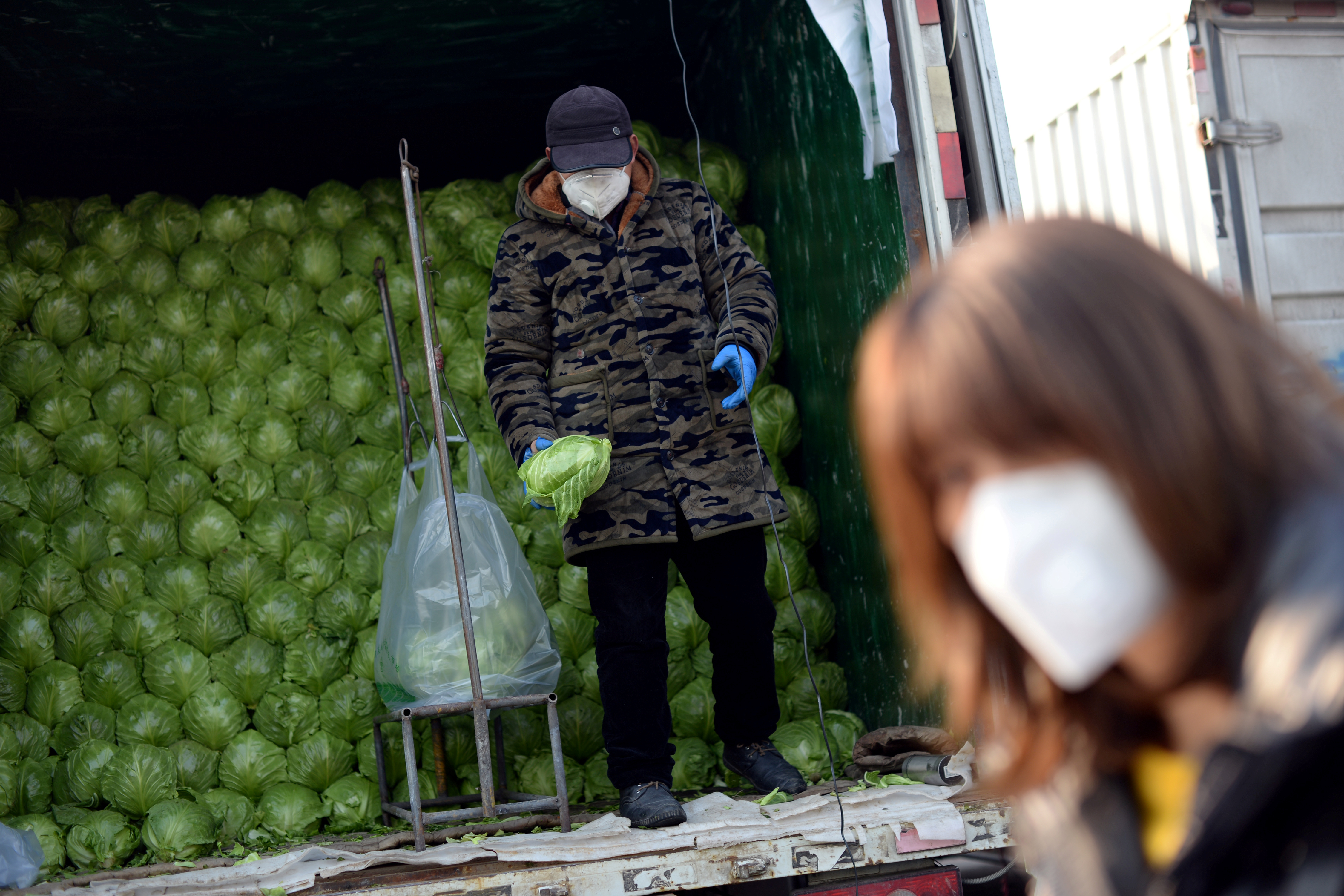 Un hombre clasifica verduras en un camión en el mercado mayorista de Xinfadi (Reuters)