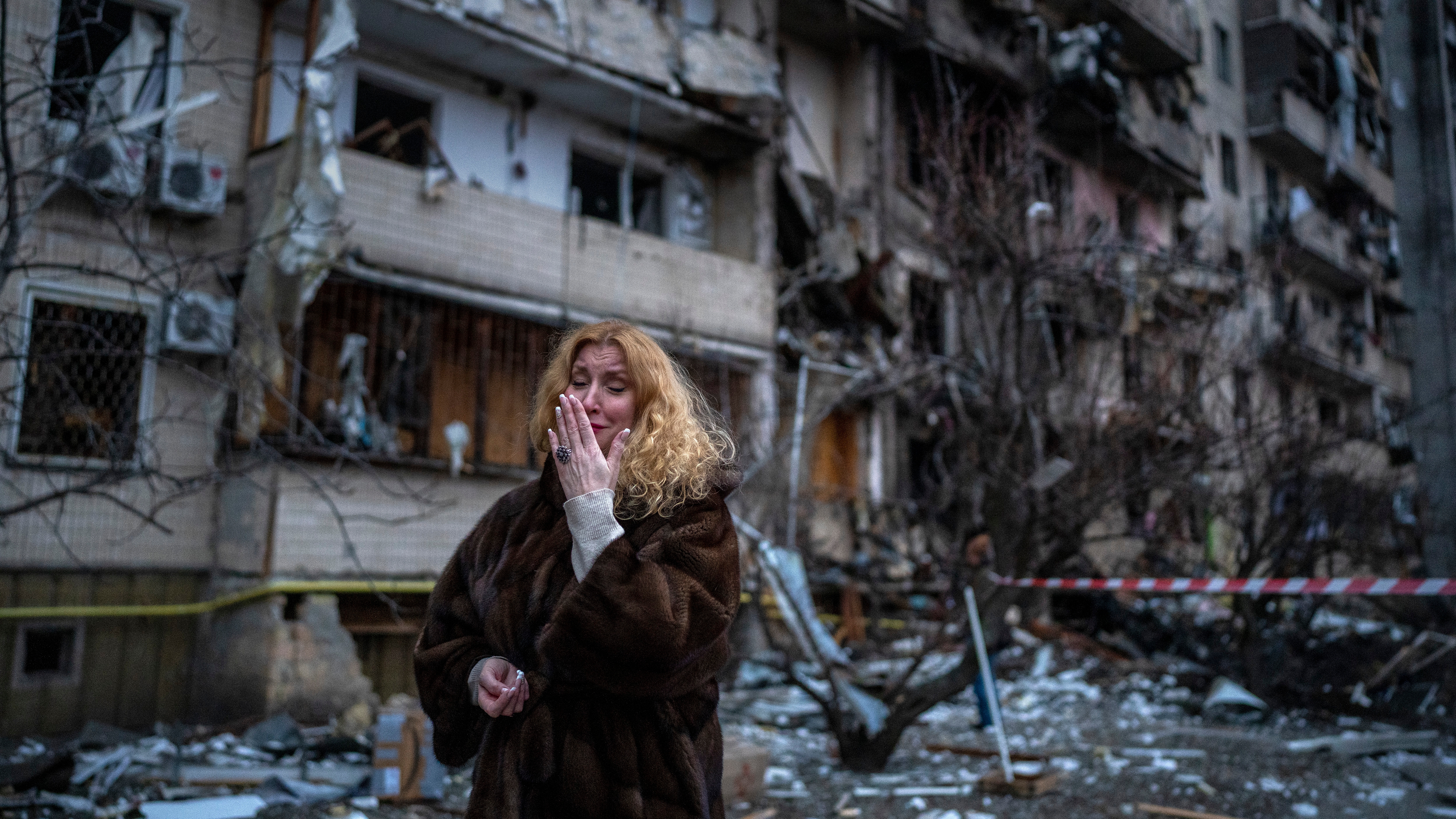 Natali Sevriukova reacts next to her house following a rocket attack the city of Kyiv, Ukraine, Friday, Feb. 25, 2022. (AP Photo/Emilio Morenatti)