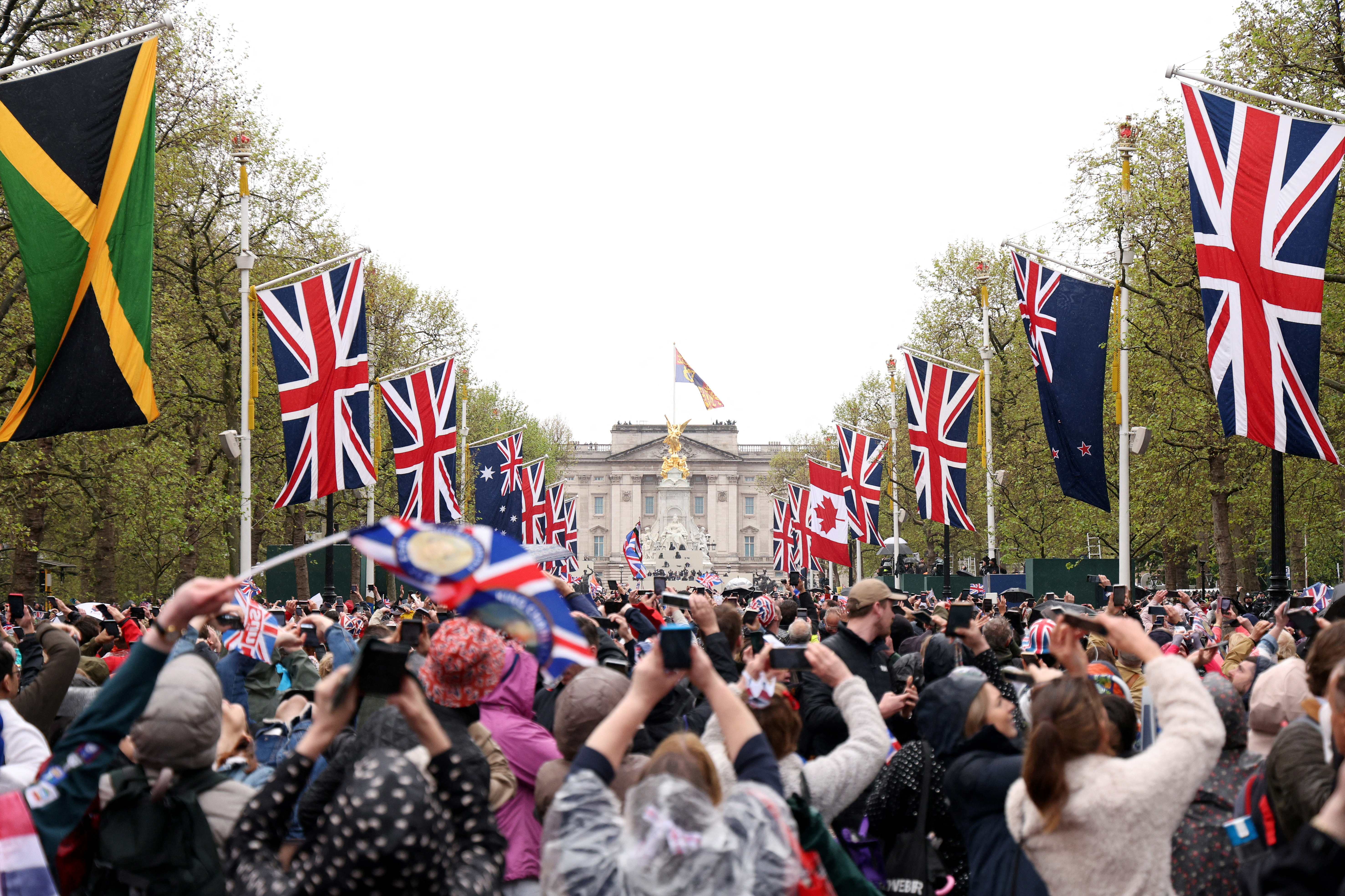 Los simpatizantes sostienen sus teléfonos para tomar fotos del Palacio de Buckingham durante la coronación del rey Carlos III y la reina Camilla el 6 de mayo 2023 en Londres, Inglaterra. Richard Heathcote/Pool vía REUTERS
