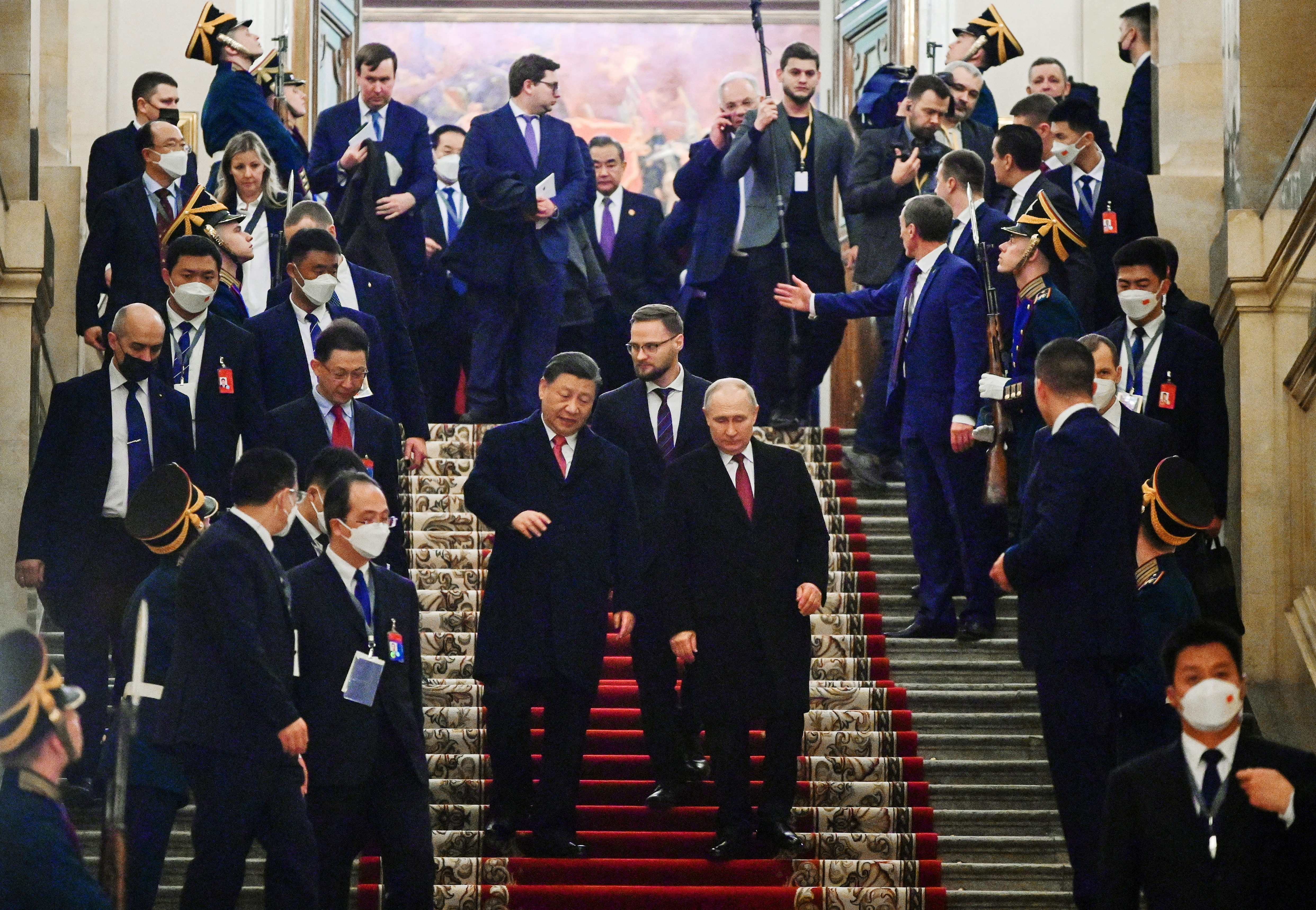 Los mandatarios caminaron frente a una hilera de funcionarios rusos y chinos para sostener su reunión. Putin y Xi vestían trajes negros y corbatas rojo oscuro. (Sputnik/Pavel Byrkin/Kremlin via REUTERS)