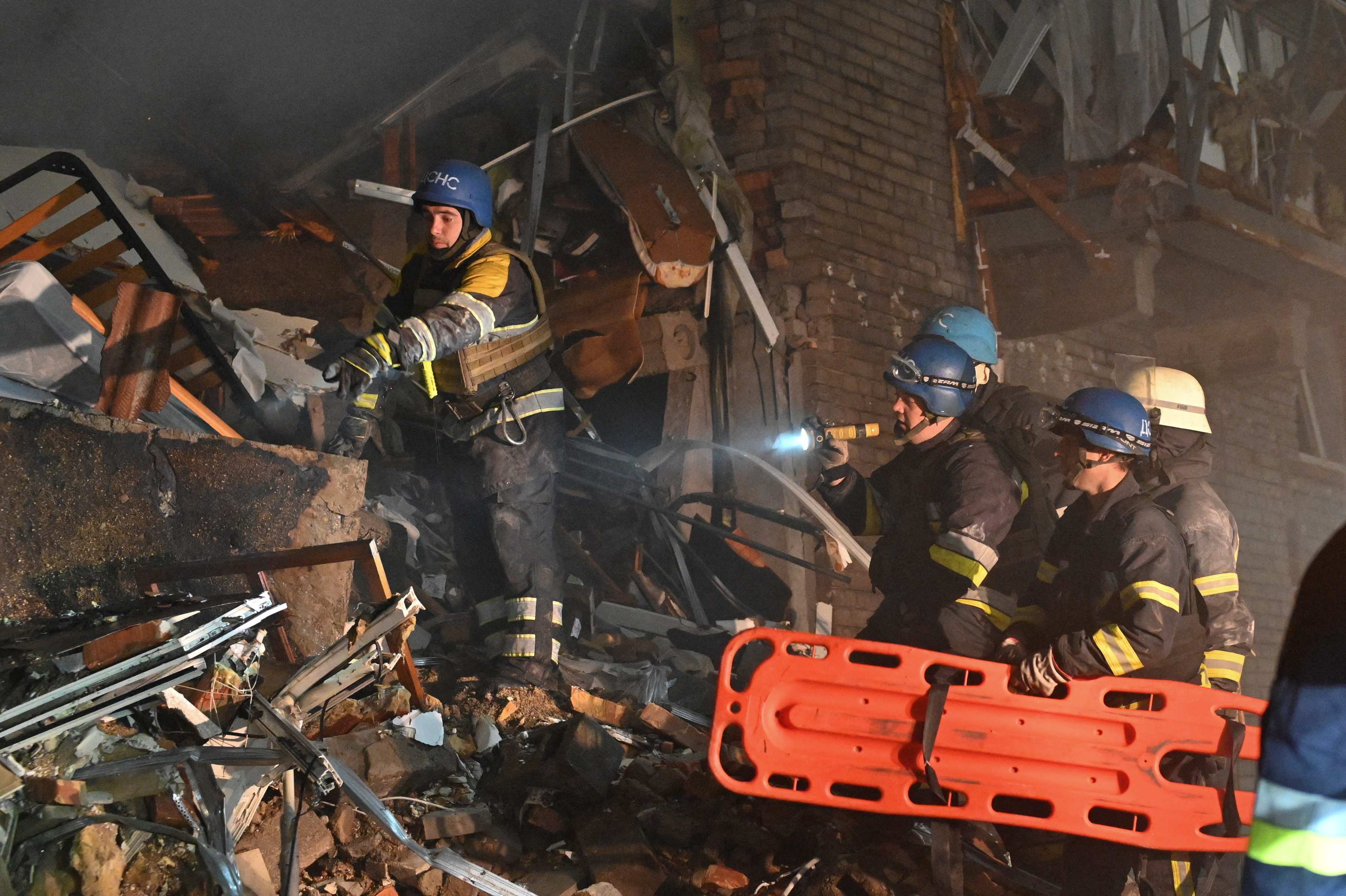Rescatistas buscan entre los escombros de un edificio a sobrevivientes en Zaporizhzhia.