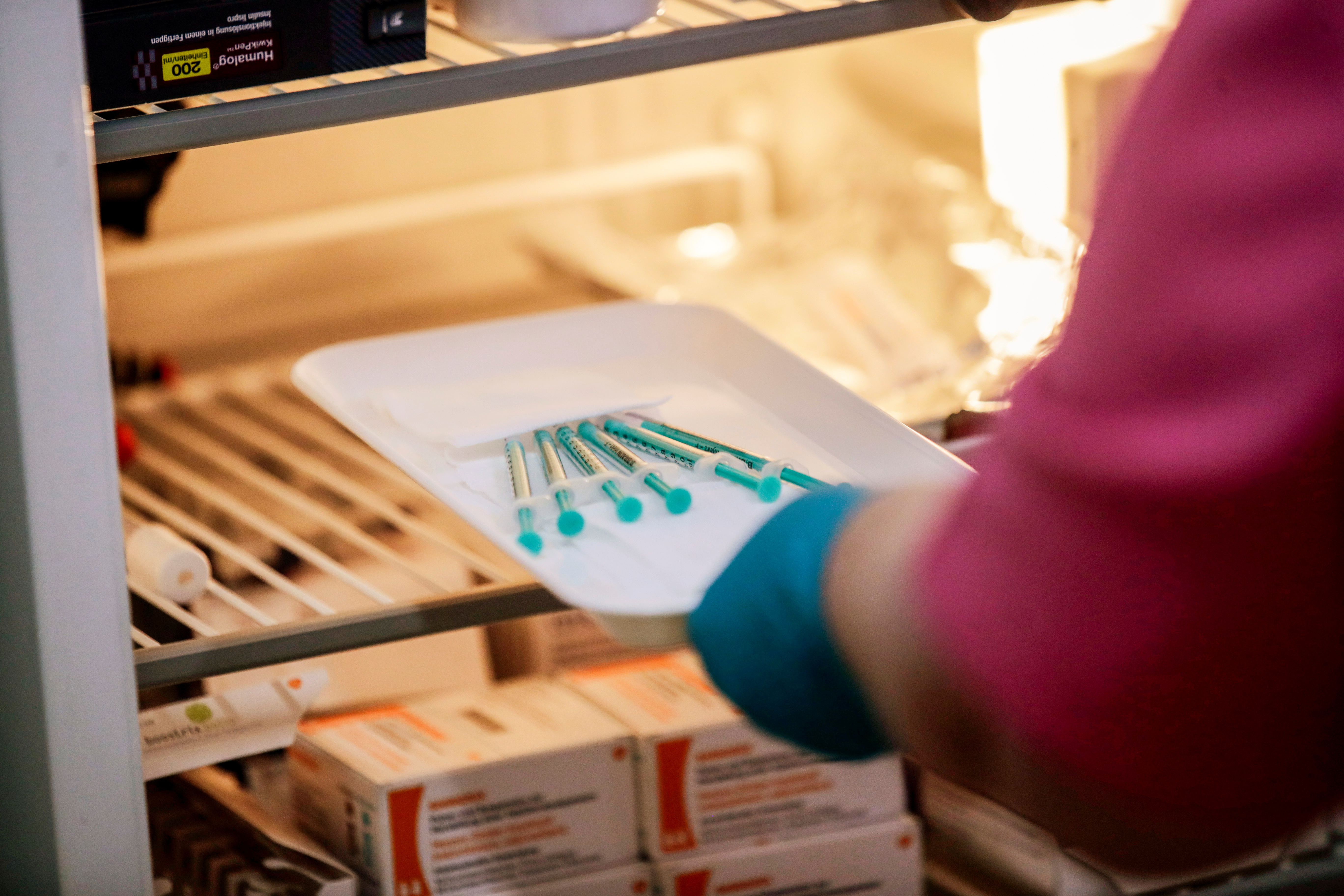 Un trabajador de la salud saca jeringas con la vacuna Pfizer-BioNTech contra la enfermedad del coronavirus (COVID-19) de un refrigerador en un consultorio médico en Berlín, Alemania, el 7 de abril de 2021. (REUTERS/Hannibal Hanschke)