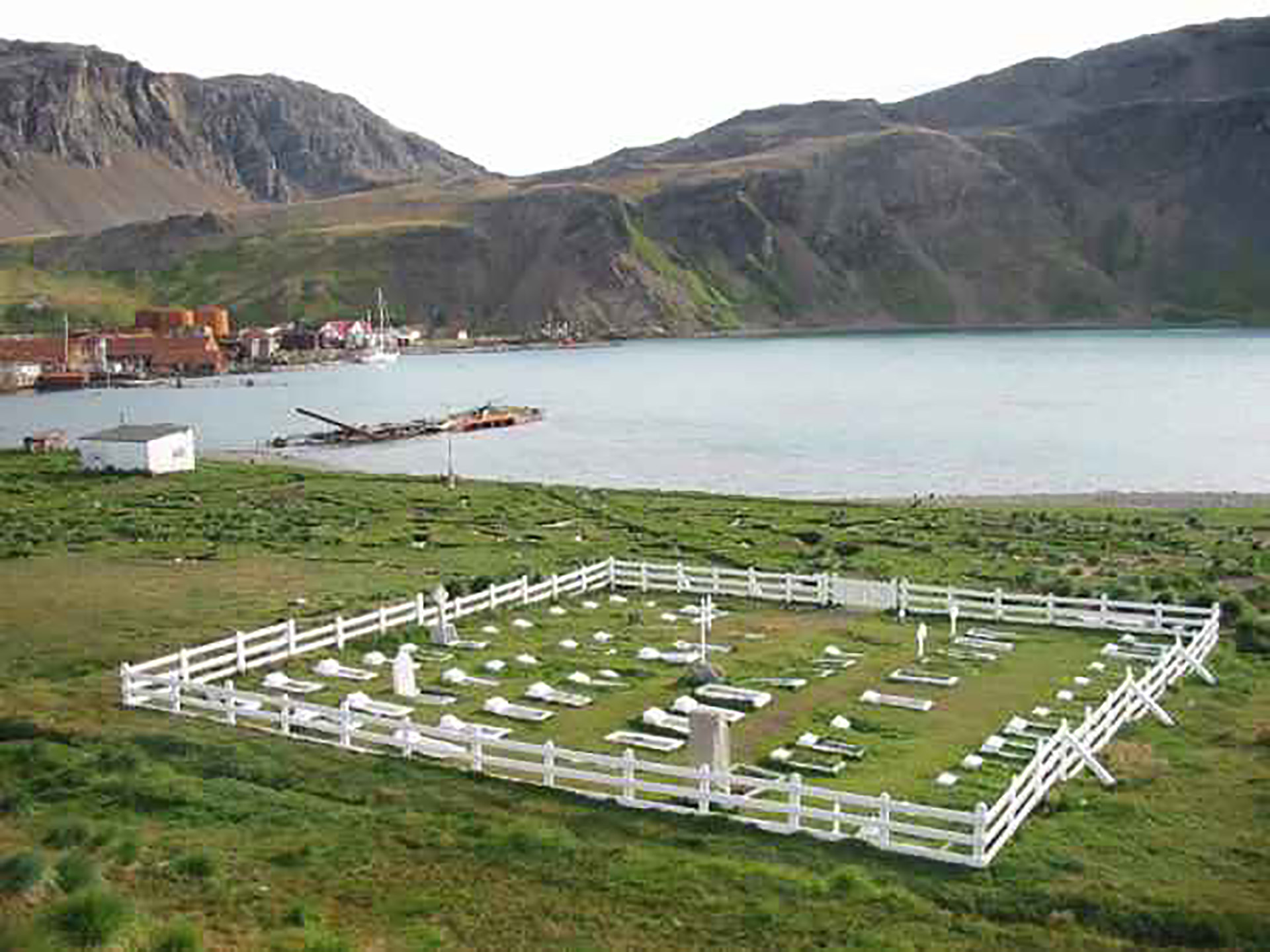 Cementerio de Grytviken, donde descansan los restos del único héroe argentino enterrado en las Georgias. Hace años un profesor canadiense que corría la Regata Shackleton se ofreció a llevar un arreglo floral imperecedero confeccionado por la familia y lo colocaron en la lápida
