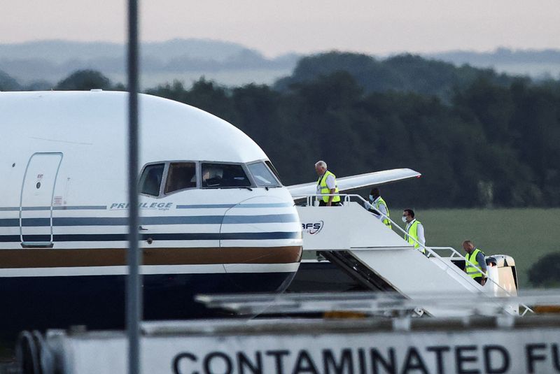 Miembros del personal suben a un avión que, según los medios de comunicación británicos, es el primero en transportar migrantes a Ruanda, en la base del Ministerio de Defensa de Boscombe Down, en Wiltshire, Reino Unido. 14 de junio de 2022. REUTERS/Henry Nicholls