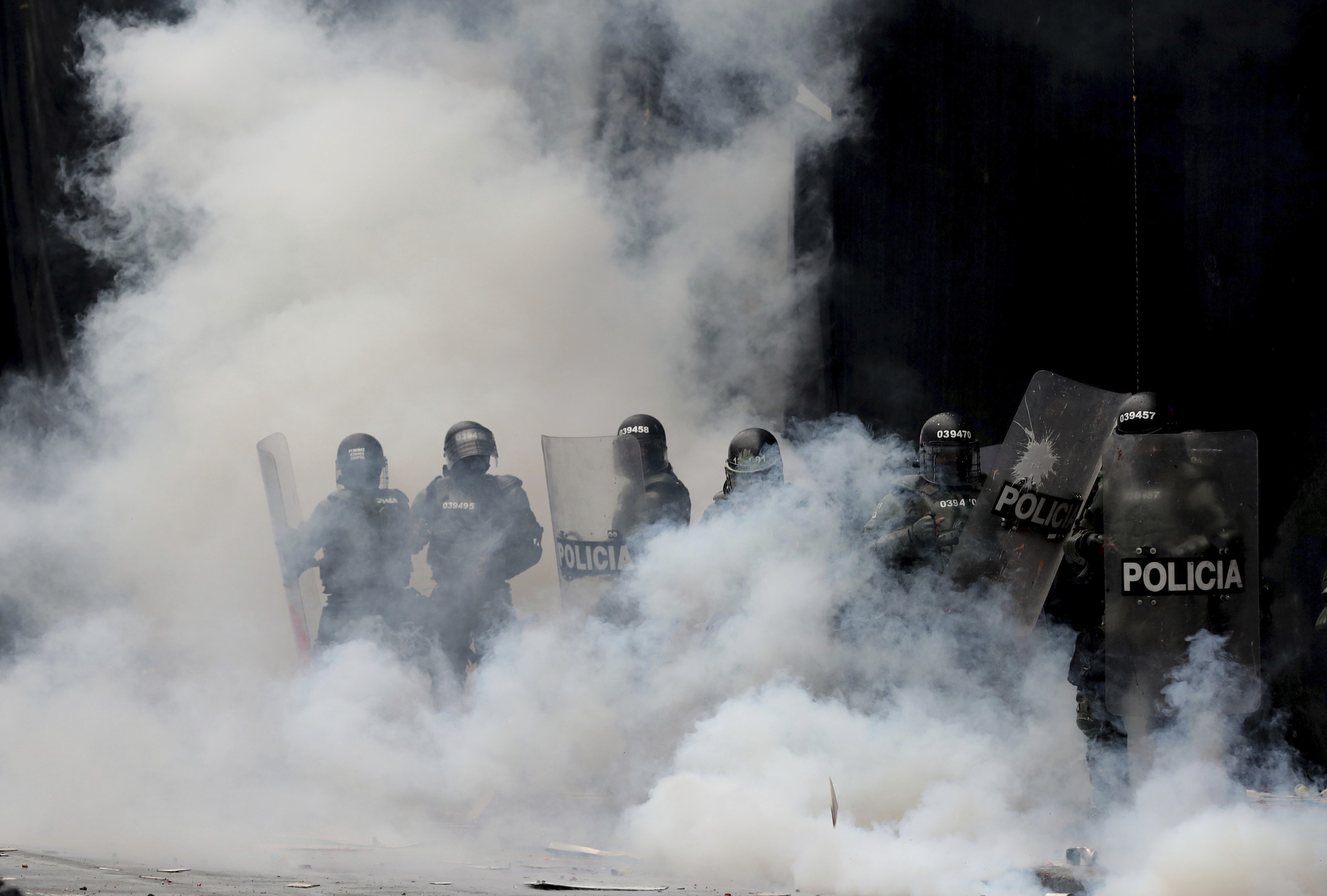 Varios policías se ven inmersos en una nube de gas lacrimógeno tras dispersar a manifestantes en la Plaza Bolívar, en el centro de Bogotá, Colombia, el jueves 21 de noviembre de 2019. (AP Foto/Fernando Vergara)
