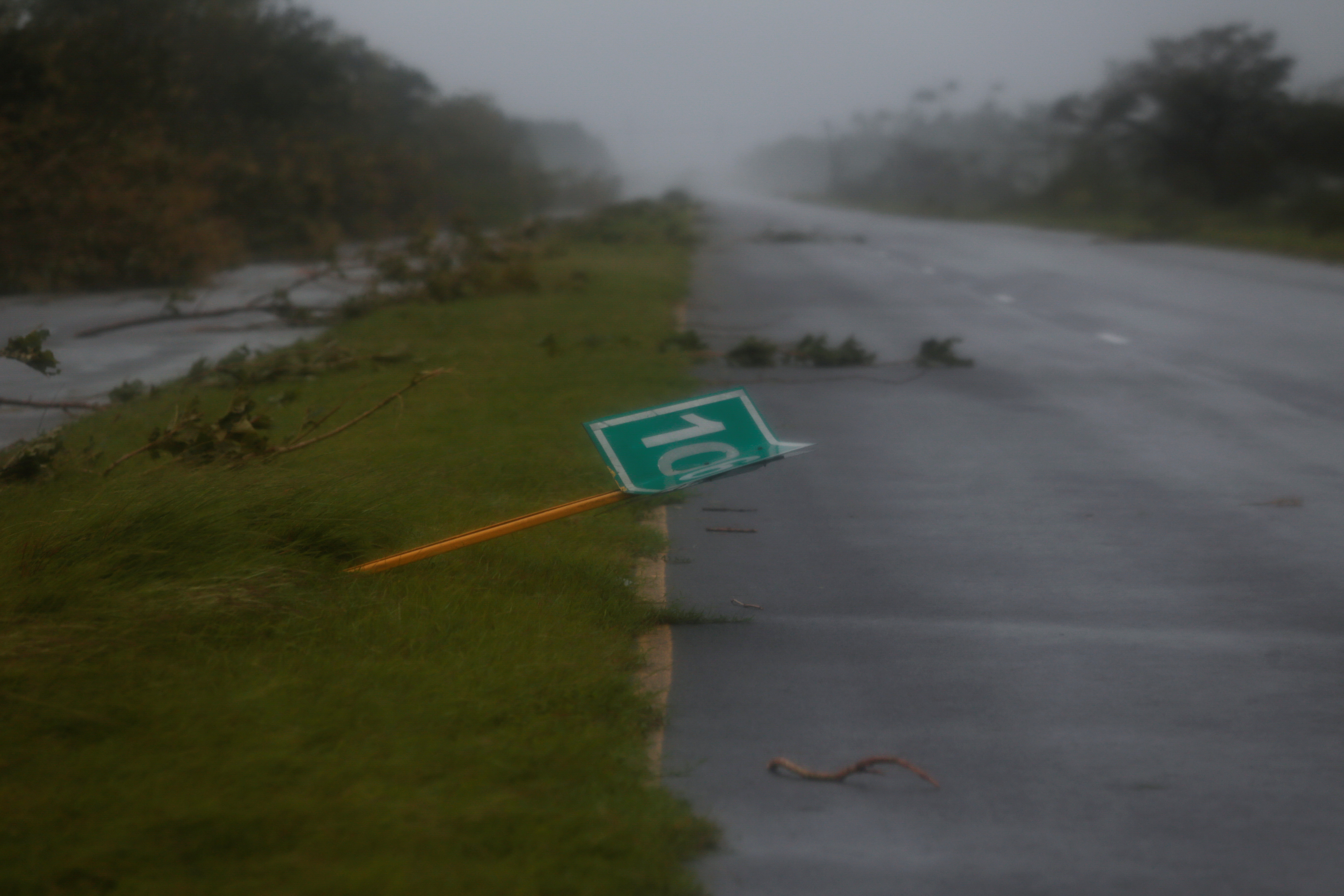 A fallen road sign and branches are pictured on a highway after Hurricane Ian made landfall in Cuba's Pinar del Rio province earlier, in Consulacion del Sur, Cuba September 27, 2022. REUTERS/Stringer NO RESALES. NO ARCHIVES
