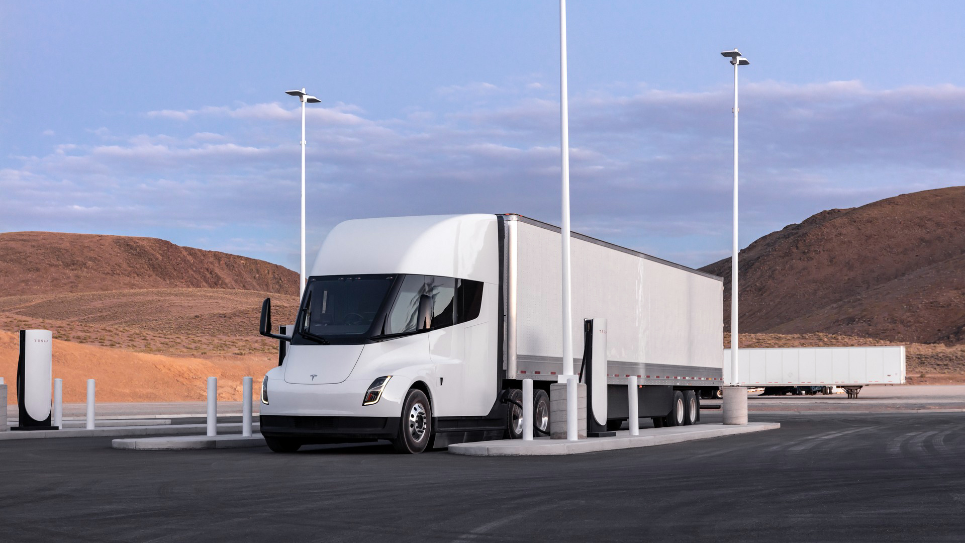A Tesla Semi in a dedicated charging station so that in half an hour the truck can return to the route