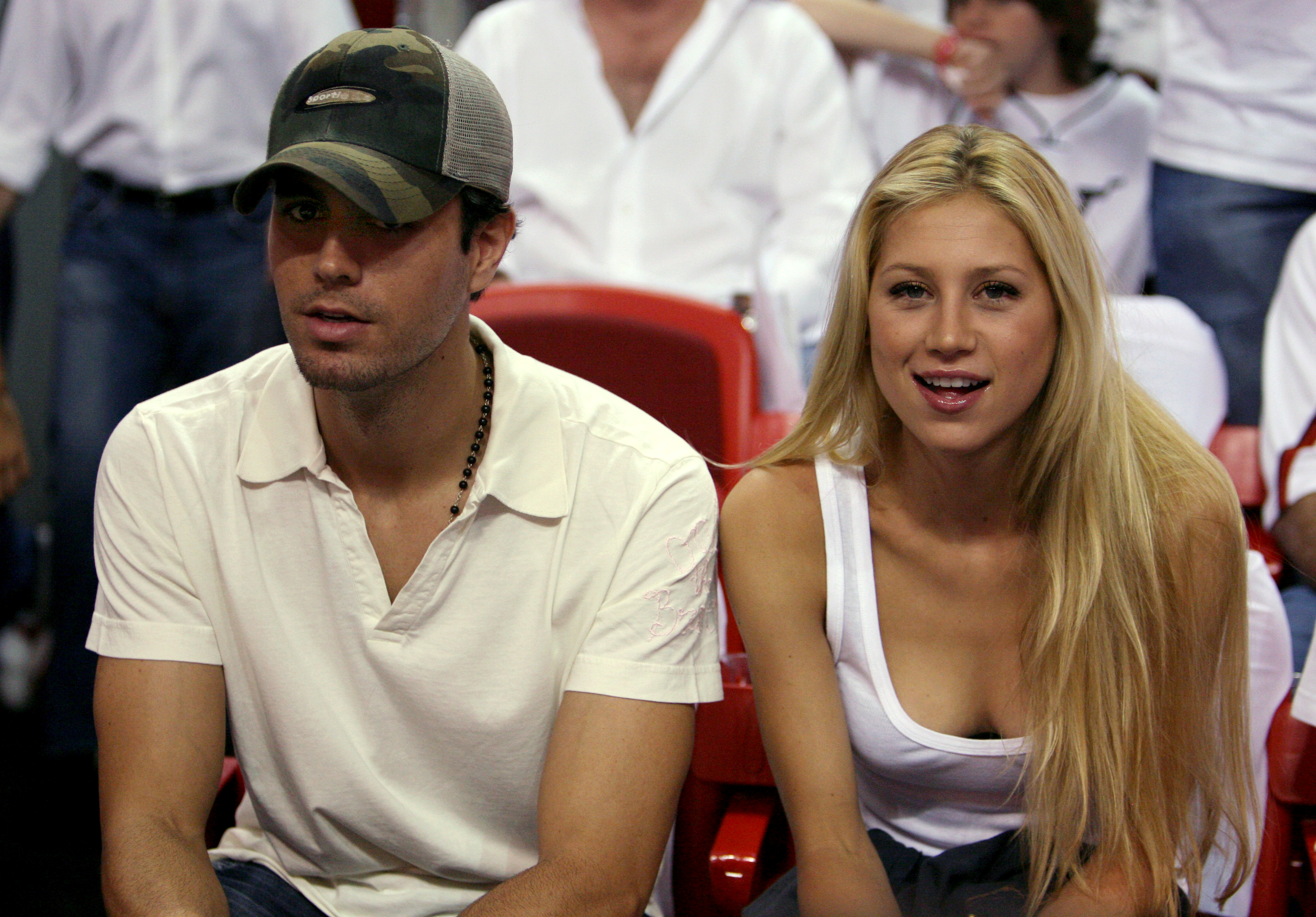 FILE PHOTO: Singer Enrique Iglesias (L) and tennis star Anna Kournikova of Russia watch as the [Dallas Mavericks meets the Miami Heat during Game 3] of their NBA Finals basketball game in Miami June 13, 2006/File Photo