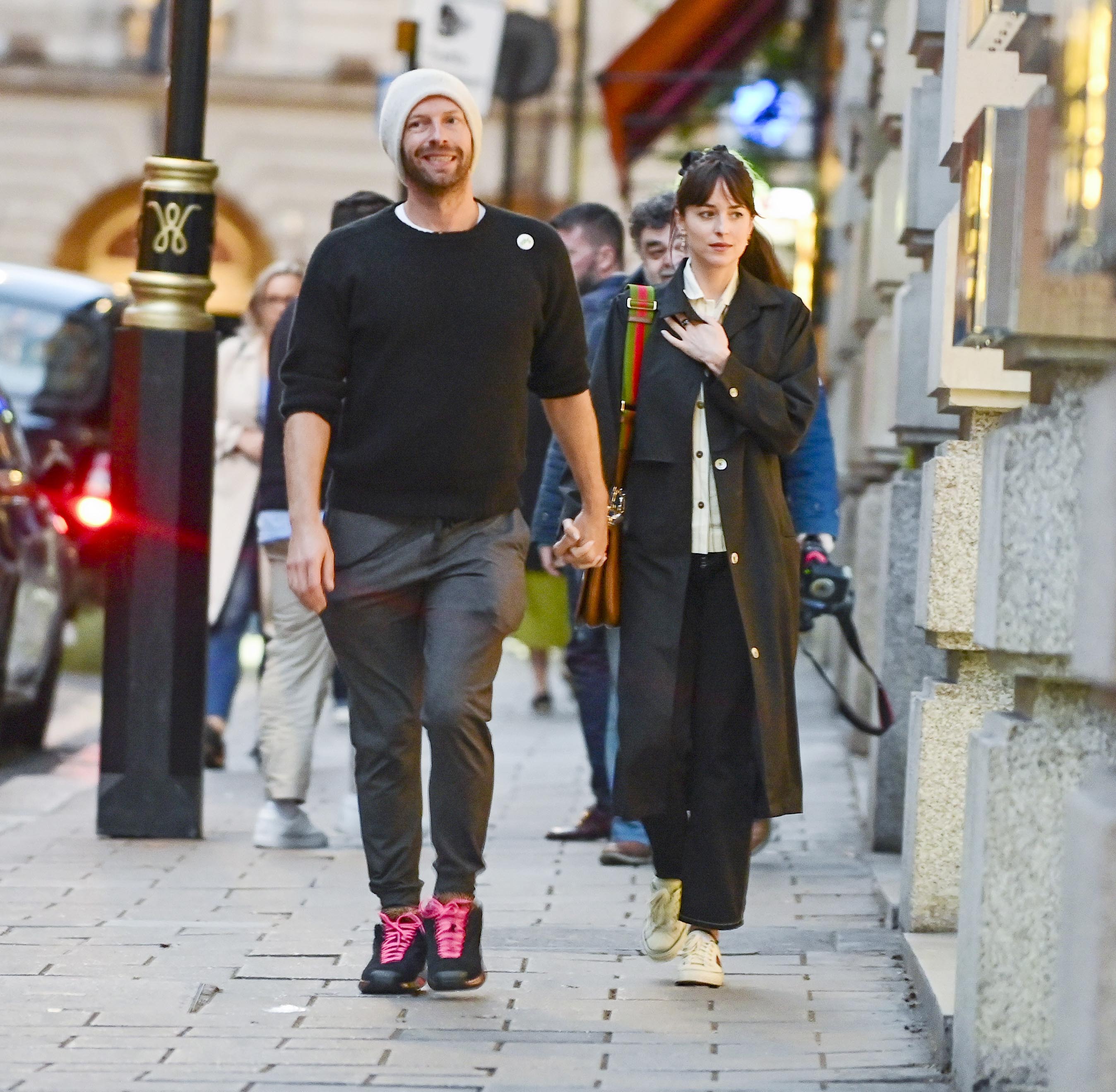 romantic walk  Chris Martin and Dakota Johnson walked the streets of London and shopped at exclusive venues.  They were photographed while walking hand in hand before entering an exclusive restaurant to eat