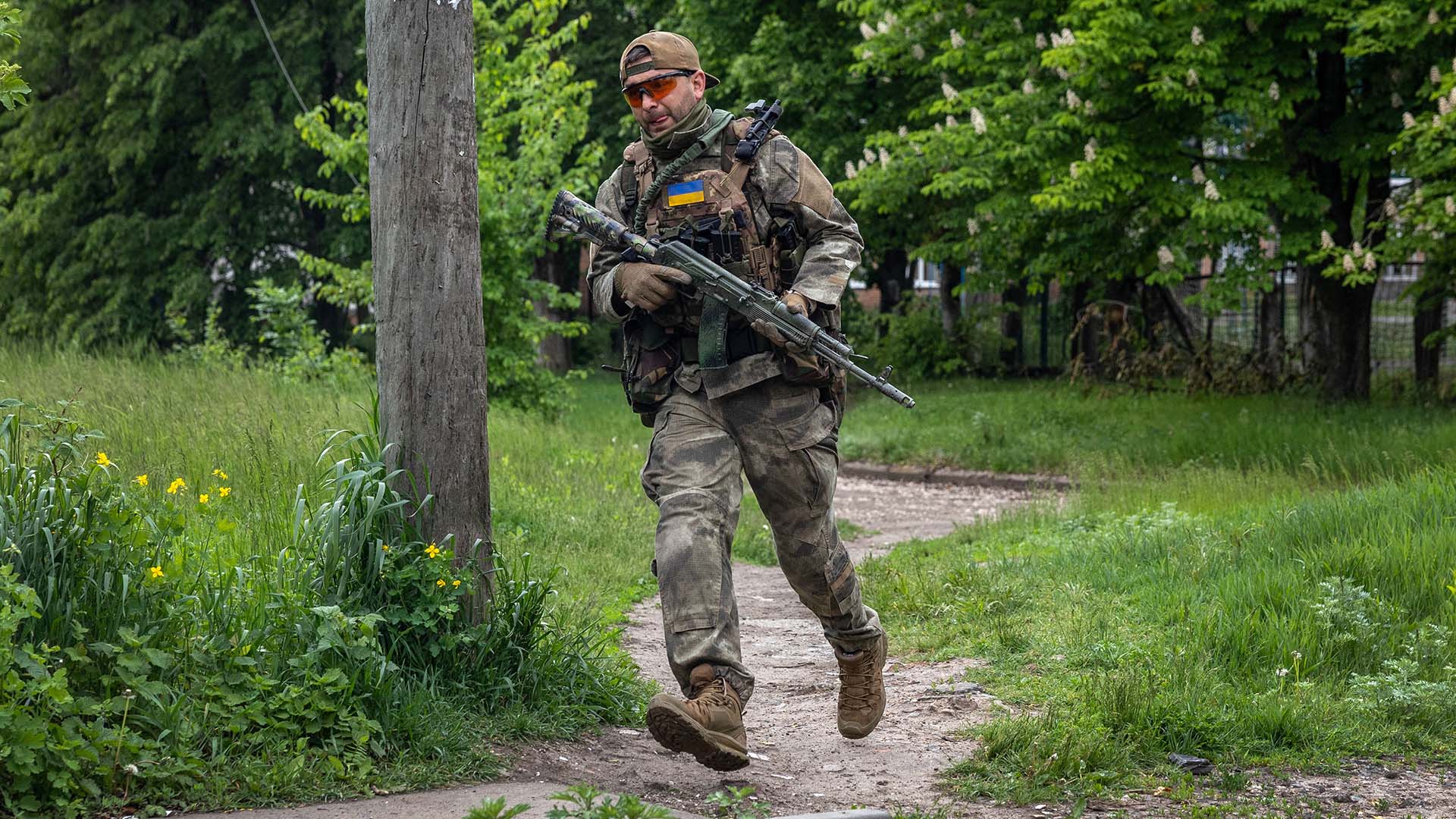 Soldados de la Defensa Territorial Ucraniana corren mientras se encuentran en una posición expuesta a las tropas rusas cerca de la línea del frente el 22 de mayo de 2022 cerca de Ruska Lozova, Ucrania.