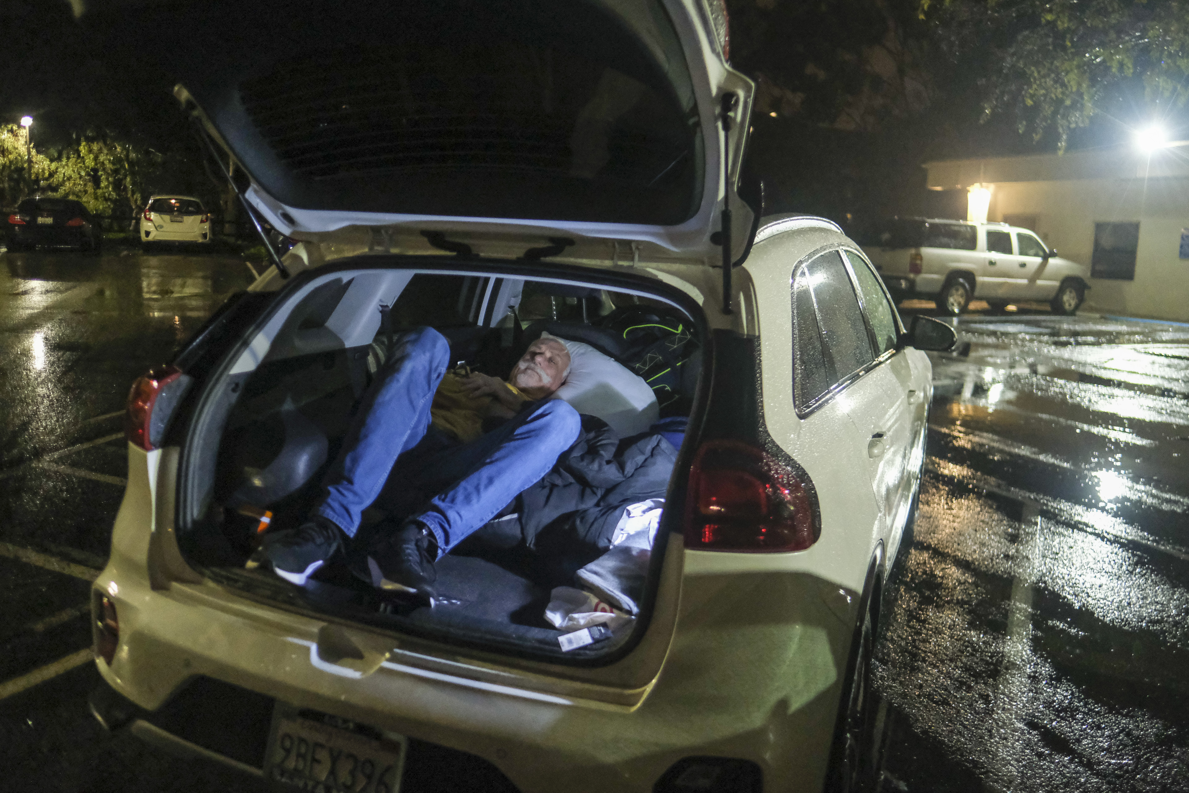 Duck Derrington, de 61 años y residente de Lompoc, duerme en su automóvil en el estacionamiento de un centro de evacuación en Santa Bárbara, California. (Foto AP/Ringo H.W. Chiu)
