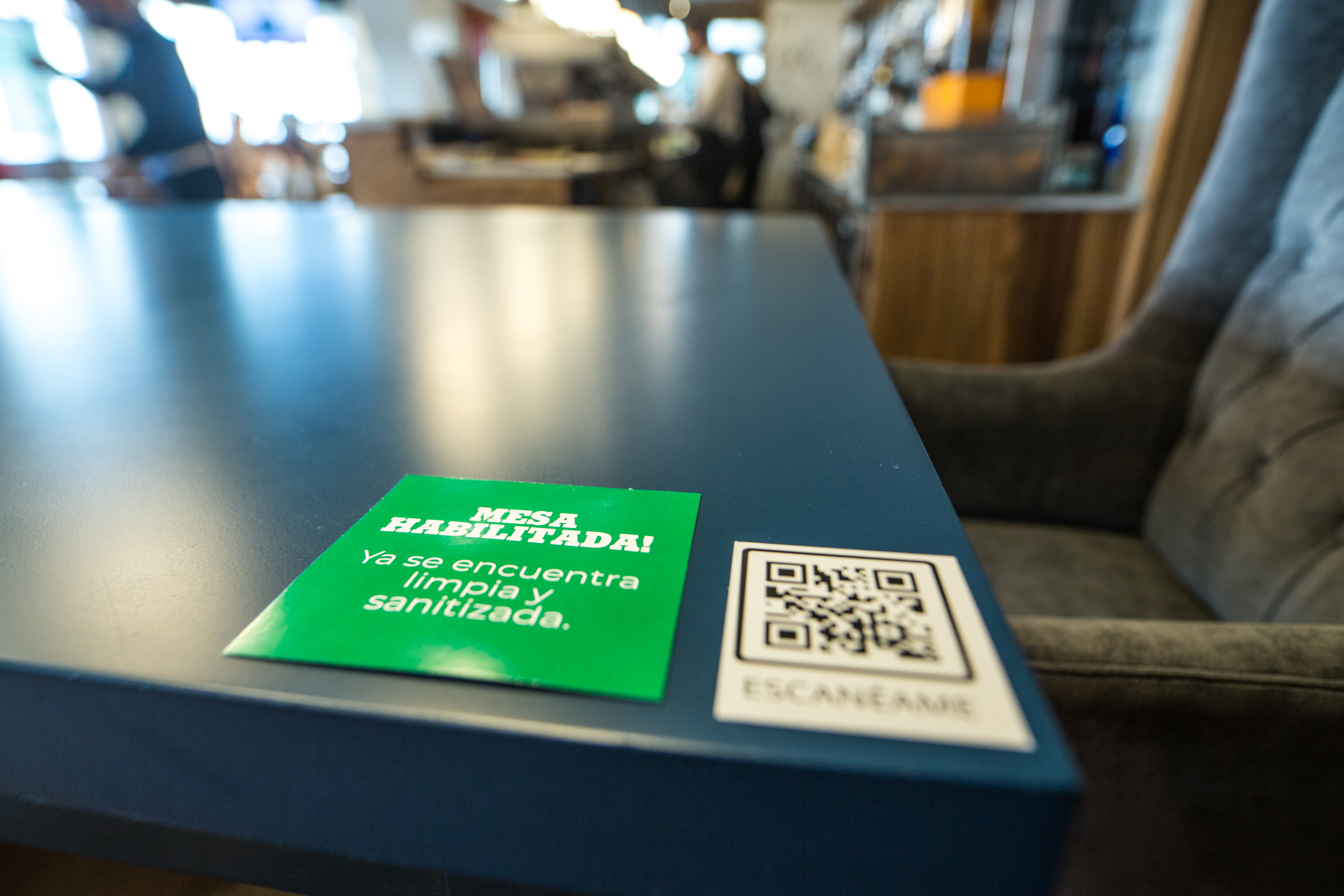 El cartel tiene dos caras: la verde indica que la mesa fue desinfectada y se puede usar. Del otro lado es roja y señala que aún no se puede ocupar. El código QR tiene la carta. Adiós a las de papel.