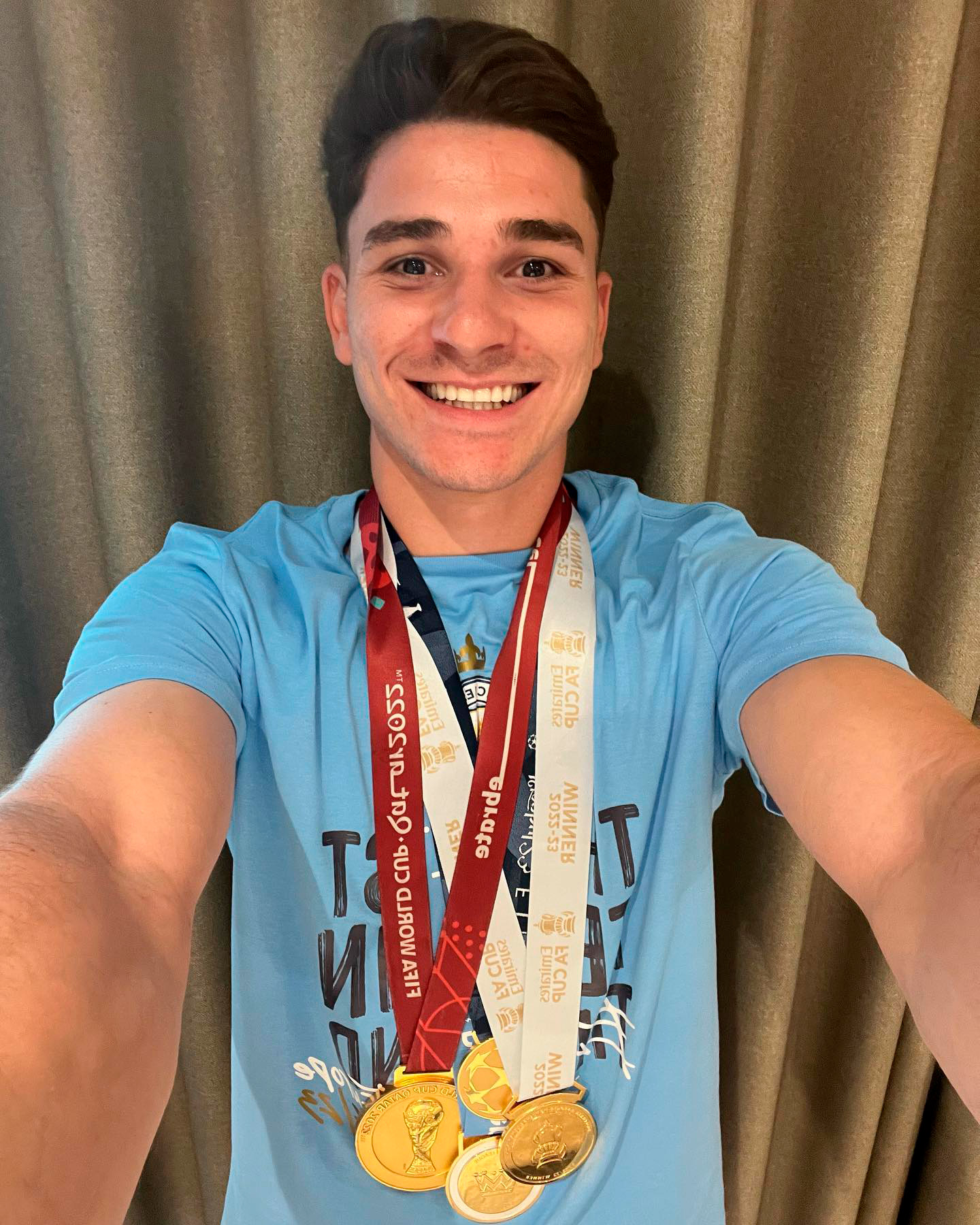 Julián Álvarez sonríe con sus cuatro medallas de oro conseguidas en la temporada 2022/23 con la Selección y Manchester City (Instagram)