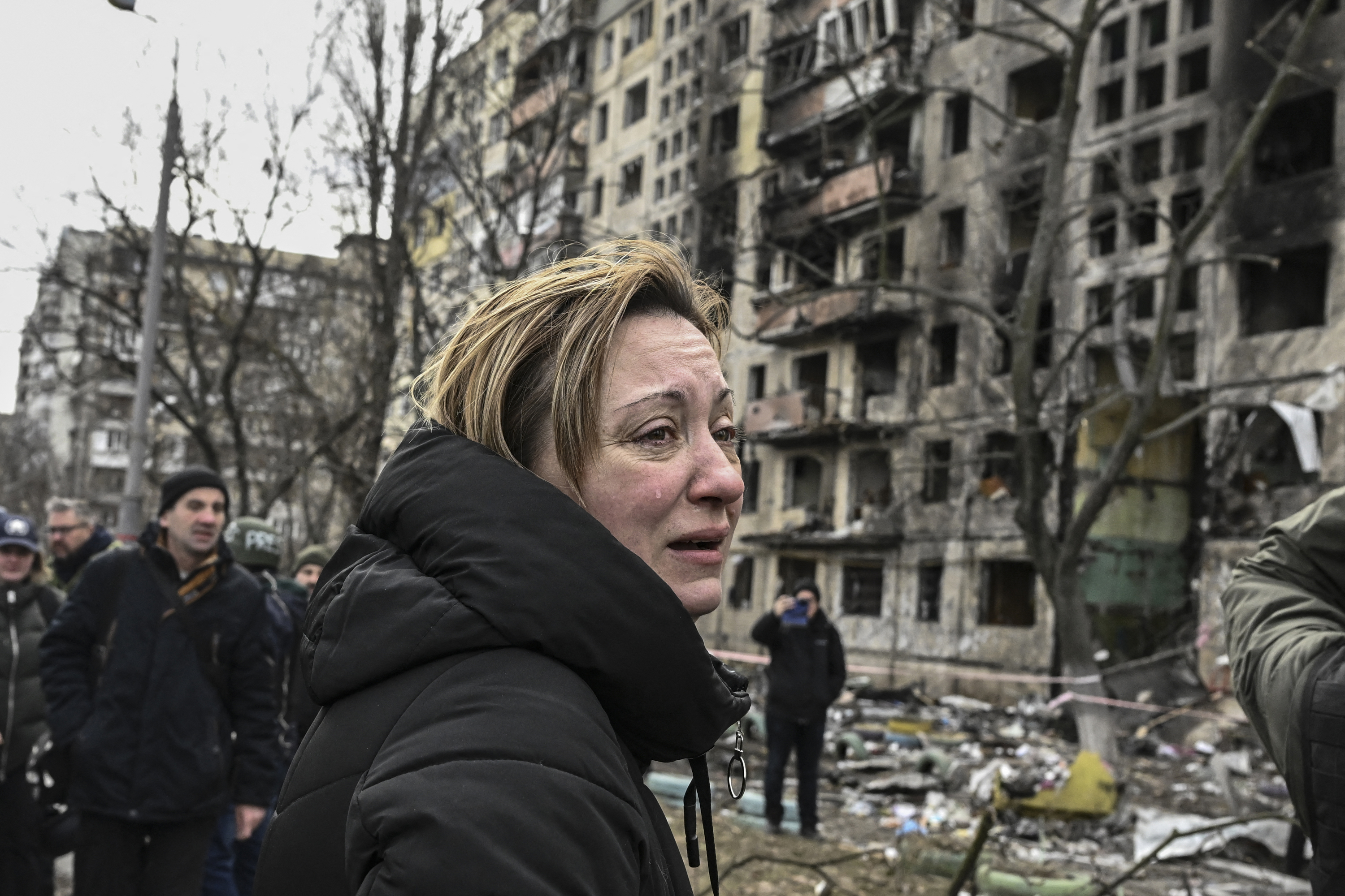 Una mujer reacciona frente a los bloques de apartamentos destruidos tras los bombardeos en el distrito de Obolon, en el noroeste de Kiev, el 14 de marzo de 2022 (Aris Messinis / AFP)
