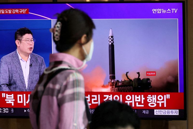 Una persona camina frente a la pantalla de una televisión en la que se muestra la imagen de un programa en el que se informa sobre el lanzamiento de tres misiles por parte de Corea del Norte, en Seúl, Corea del Sur, el 25 de mayo de 2022. REUTERS/Kim Hong-Ji