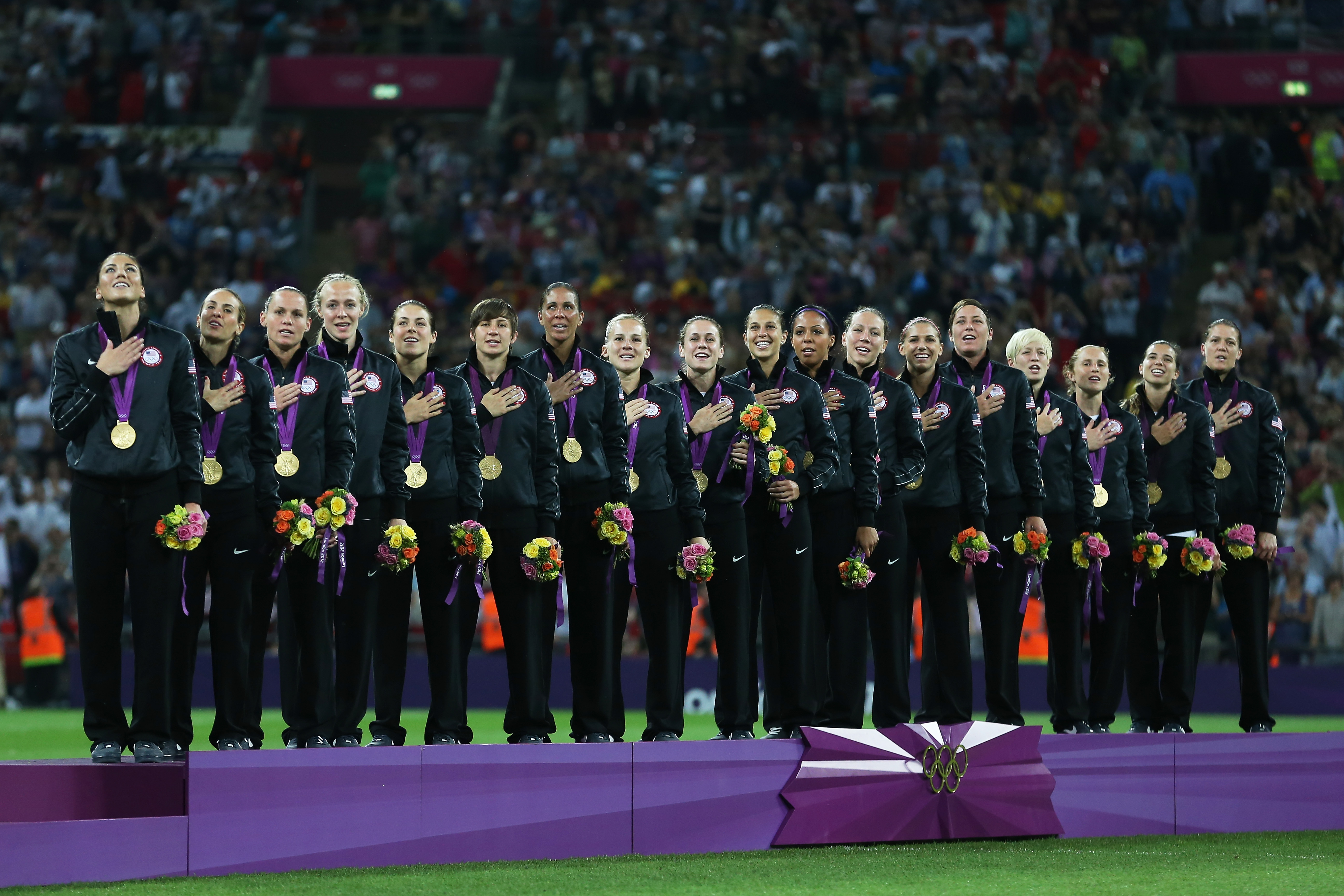 LONDON, ENGLAND - AUGUST 09: The United States women's soccer team listens to the national anthem with the the gold medal after defeating Japan by a score of 2-1 to win the Women's Football gold medal match on Day 13 of the London 2012 Olympic Games at Wembley Stadium on August 9, 2012 in London, England. (Photo by Julian Finney/Getty Images)