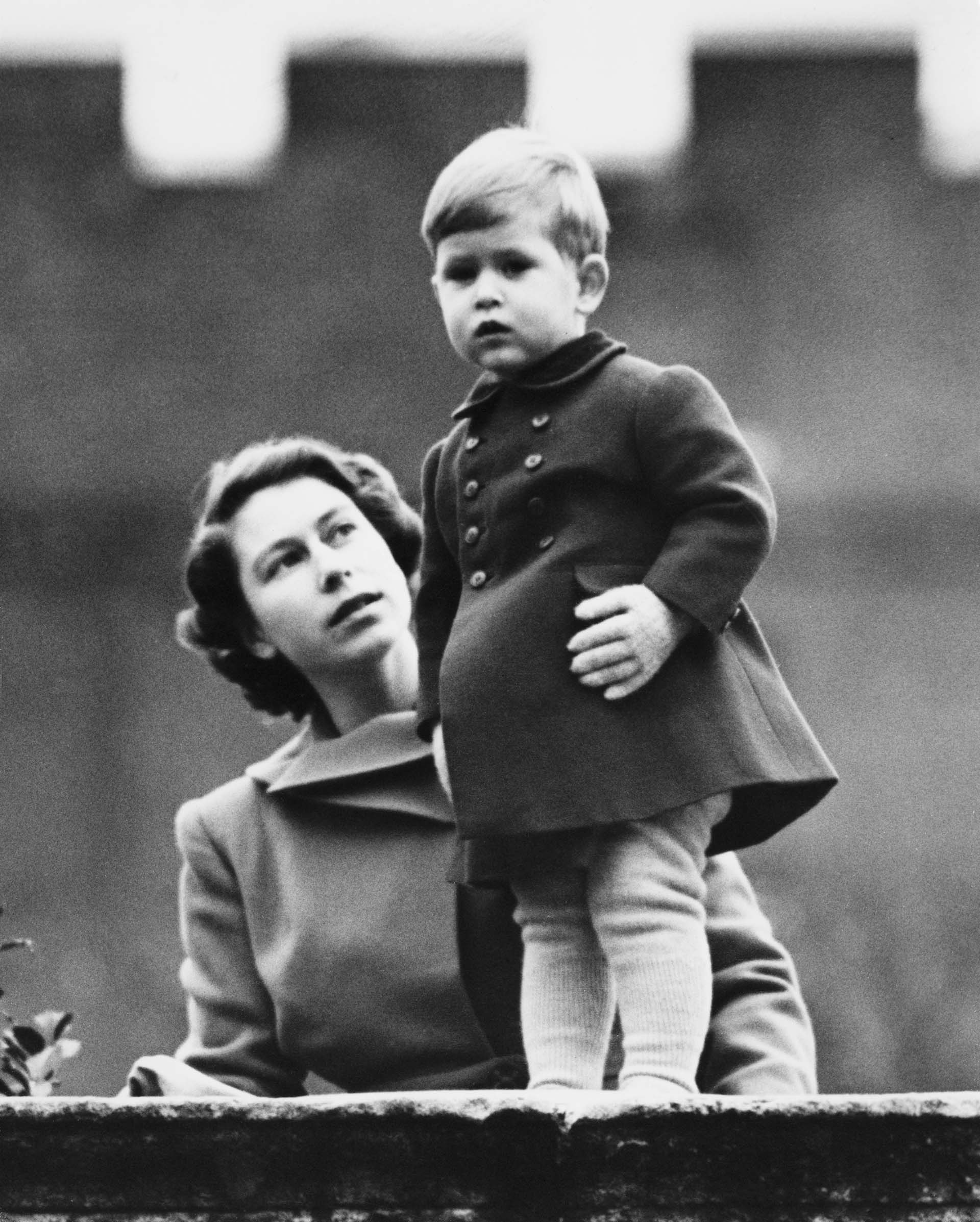 La Princesa Isabel (más tarde la Reina Isabel II) y el Príncipe Carlos observando una procesión, durante la visita de la Reina Juliana de los Países Bajos, desde el muro de Clarence House, Londres, 22 de noviembre de 1950. (Photo by Fox Photos/Hulton Archive/Getty Images)