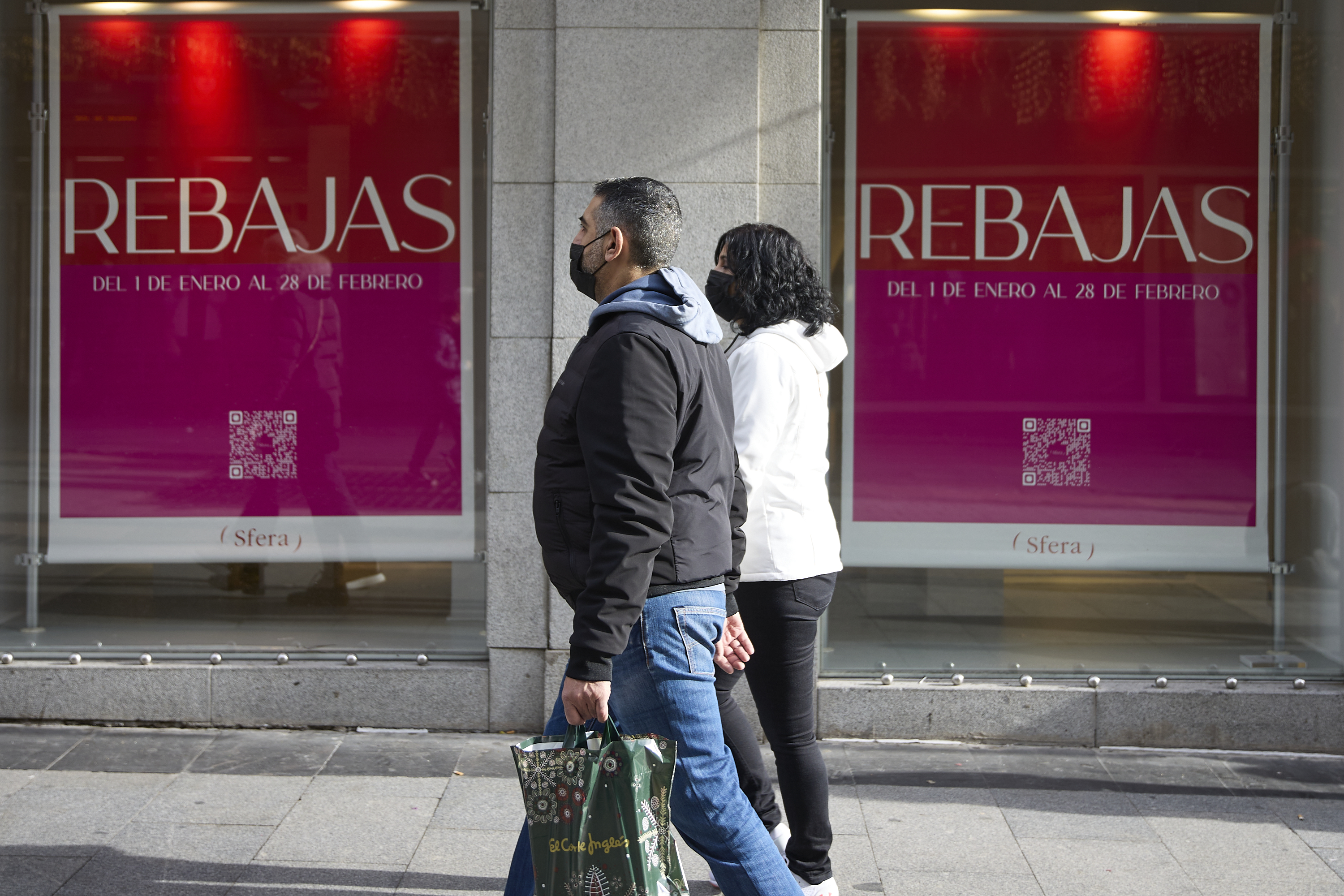 Dos personas pasan delante de una tienda con carteles de rebajas en una calle comercial del centro de Madrid, a 2 de enero de 2022, en Madrid, (España).
Jesús Hellín - Europa Press
